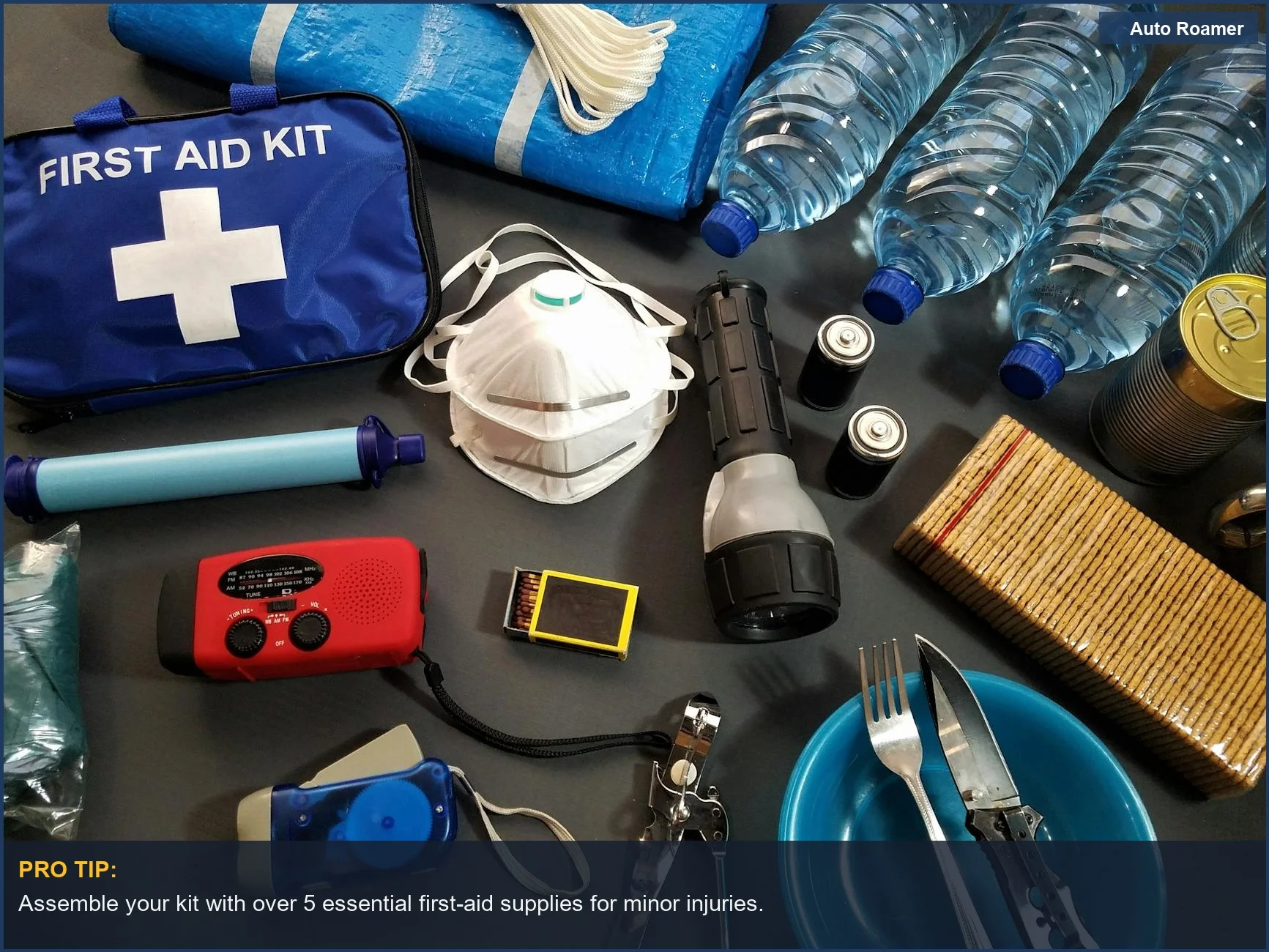 Flat lay of essential winter car emergency kit items including first aid and water bottles.