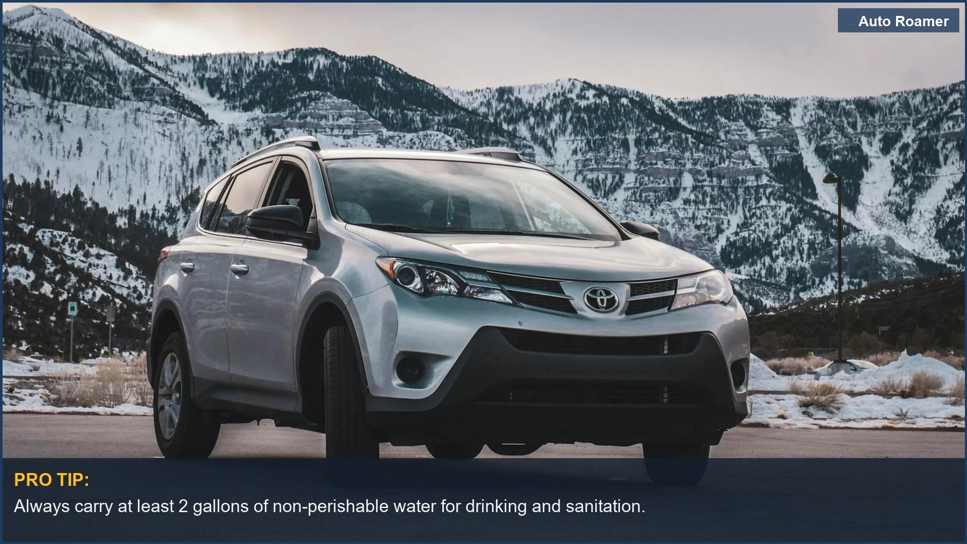 Silver SUV parked before stunning snow-covered mountains, vital for winter driving preparedness.