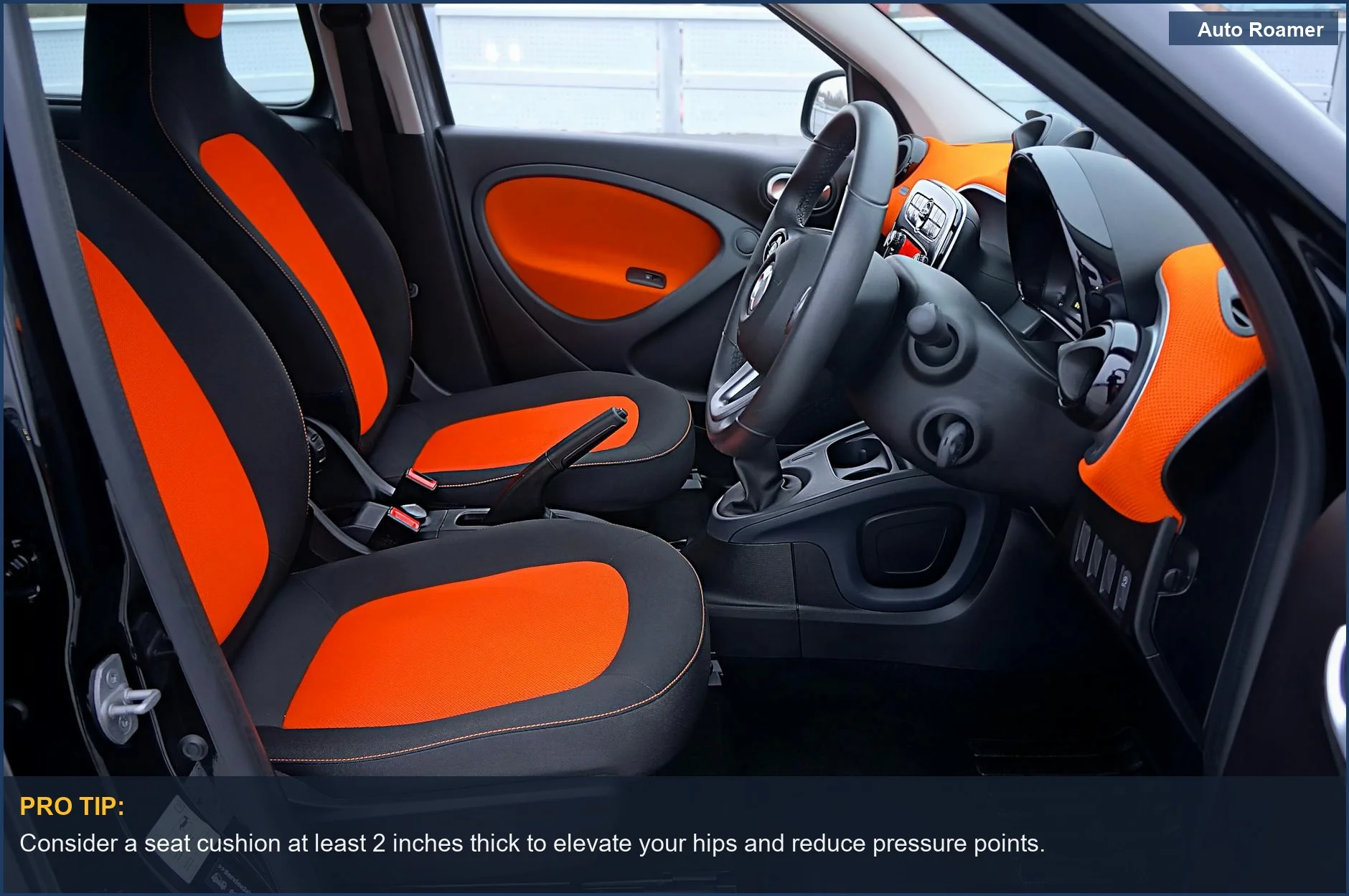 Modern car interior with orange and black seats, highlighting the need for an ergonomic car cushion.