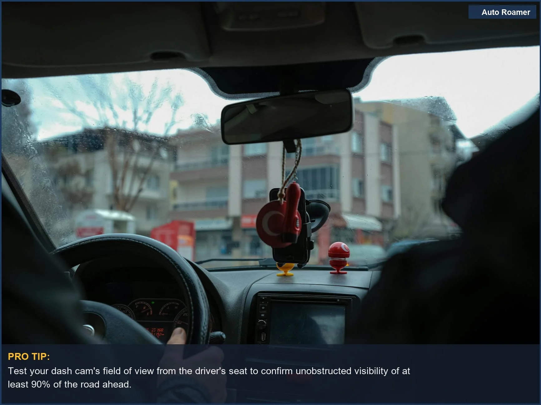 Driver's perspective navigating city streets, showing dashboard and rearview mirror for ideal dash cam placement.