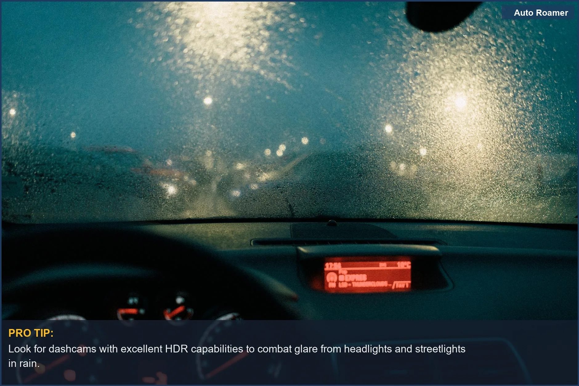 View from car interior with raindrops on windshield, highlighting dashcam performance in wet night conditions.