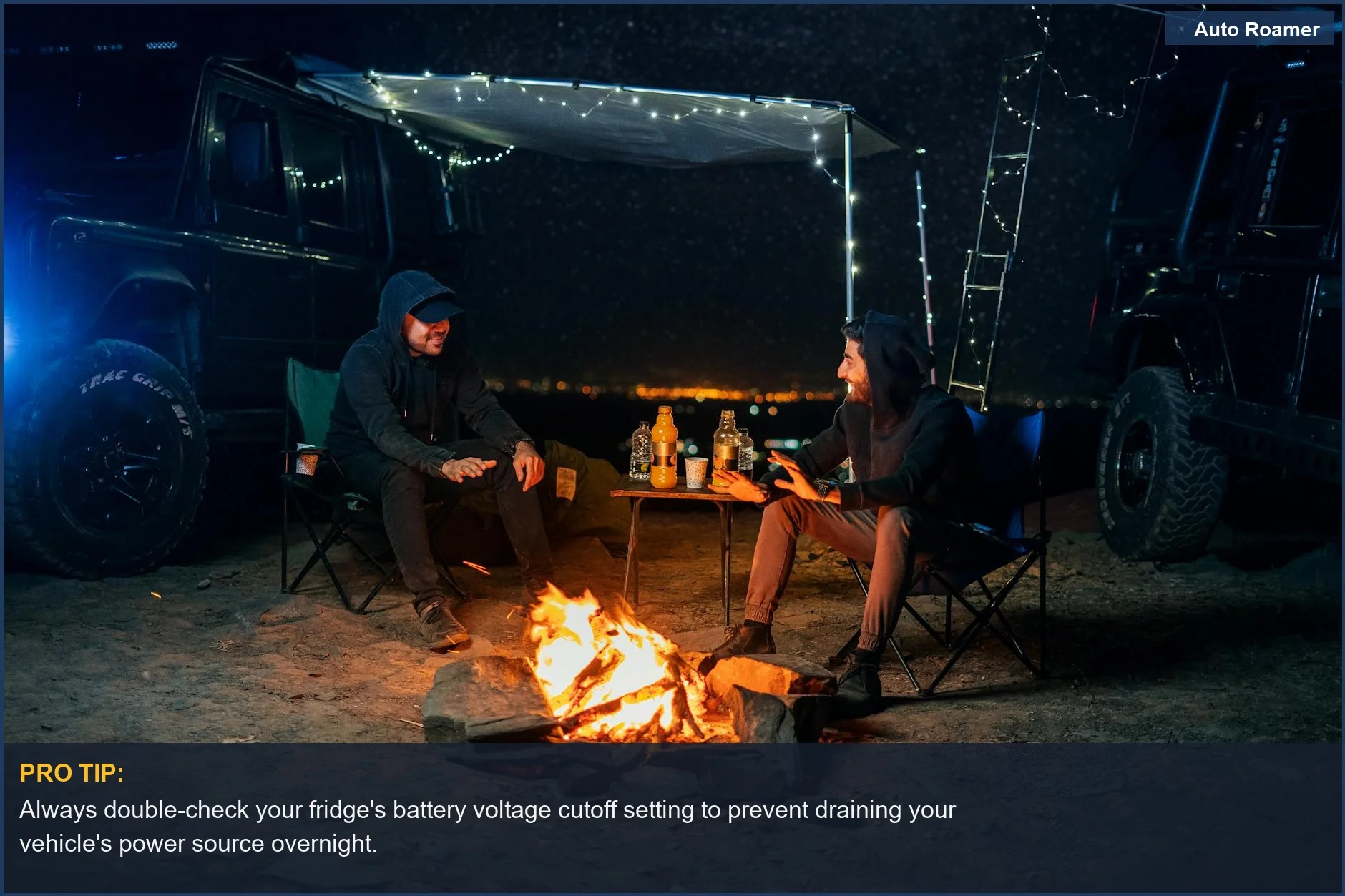 Two men camping by a campfire under a starry night sky, illustrating the cozy side of overlanding with a dual zone fridge.