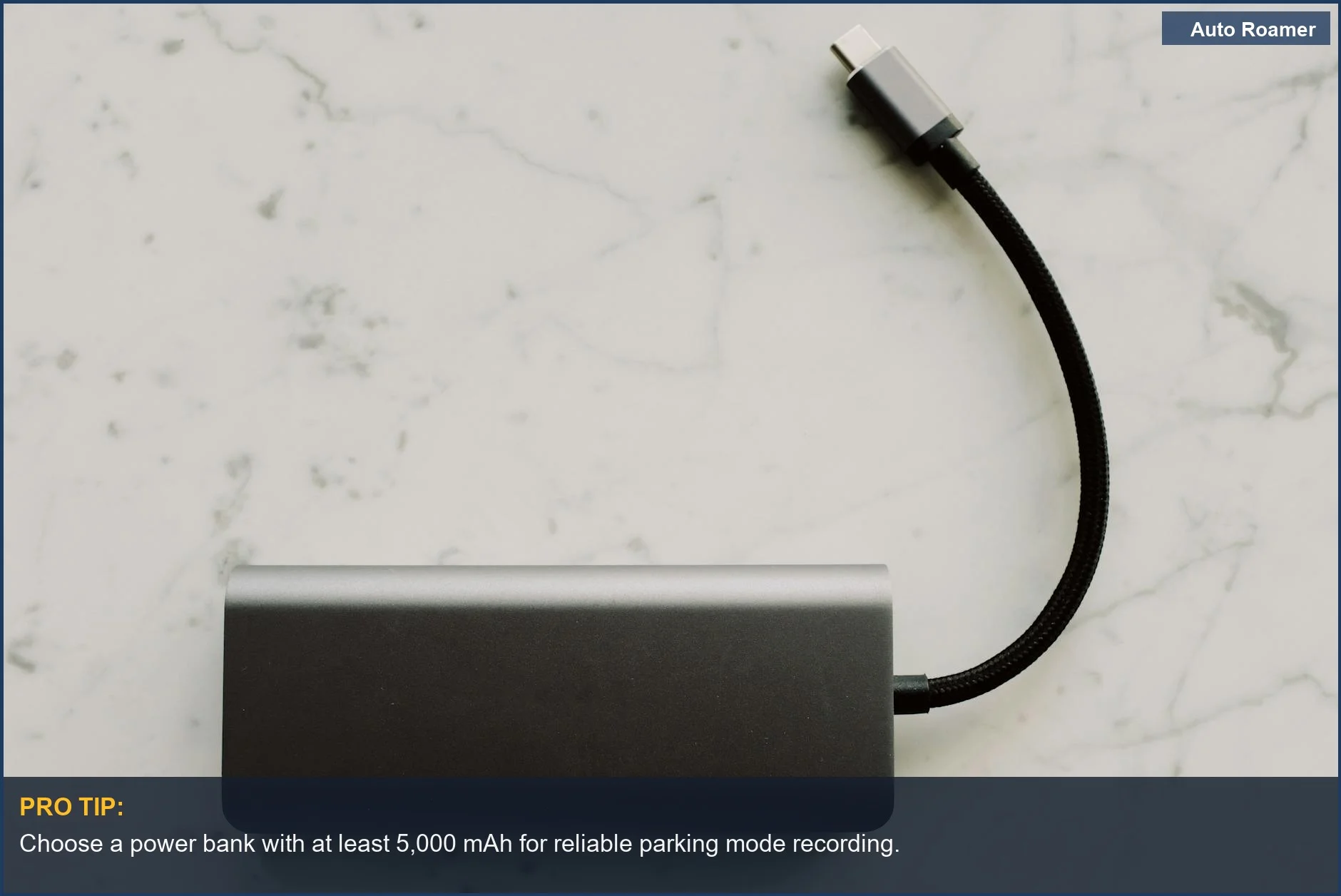 Sleek power bank with USB-C cable on marble, perfect for your dash cam's extended parking mode.