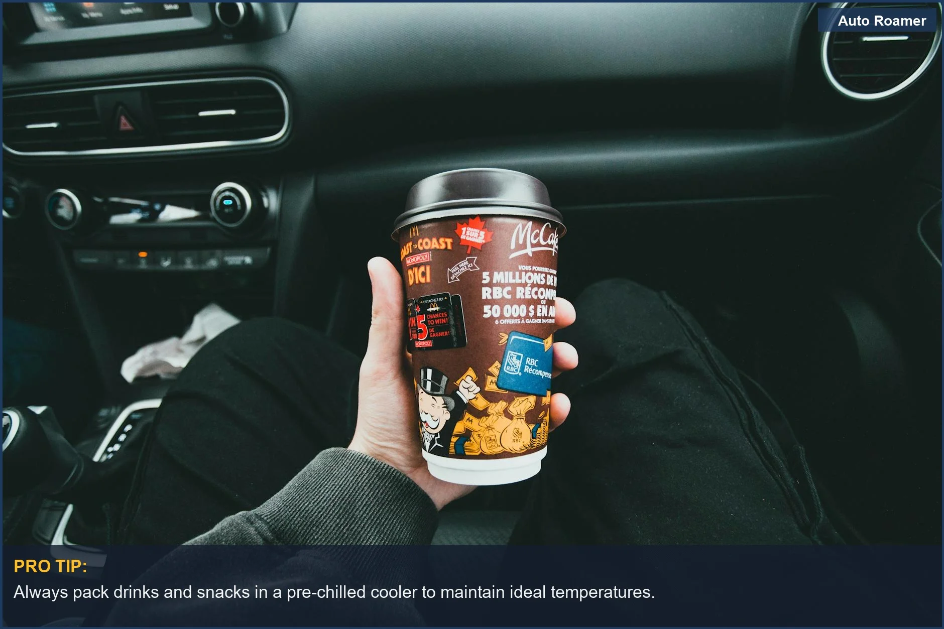 Hand holding McCafé cup inside car, a cozy scene for a portable cooler on a road trip.