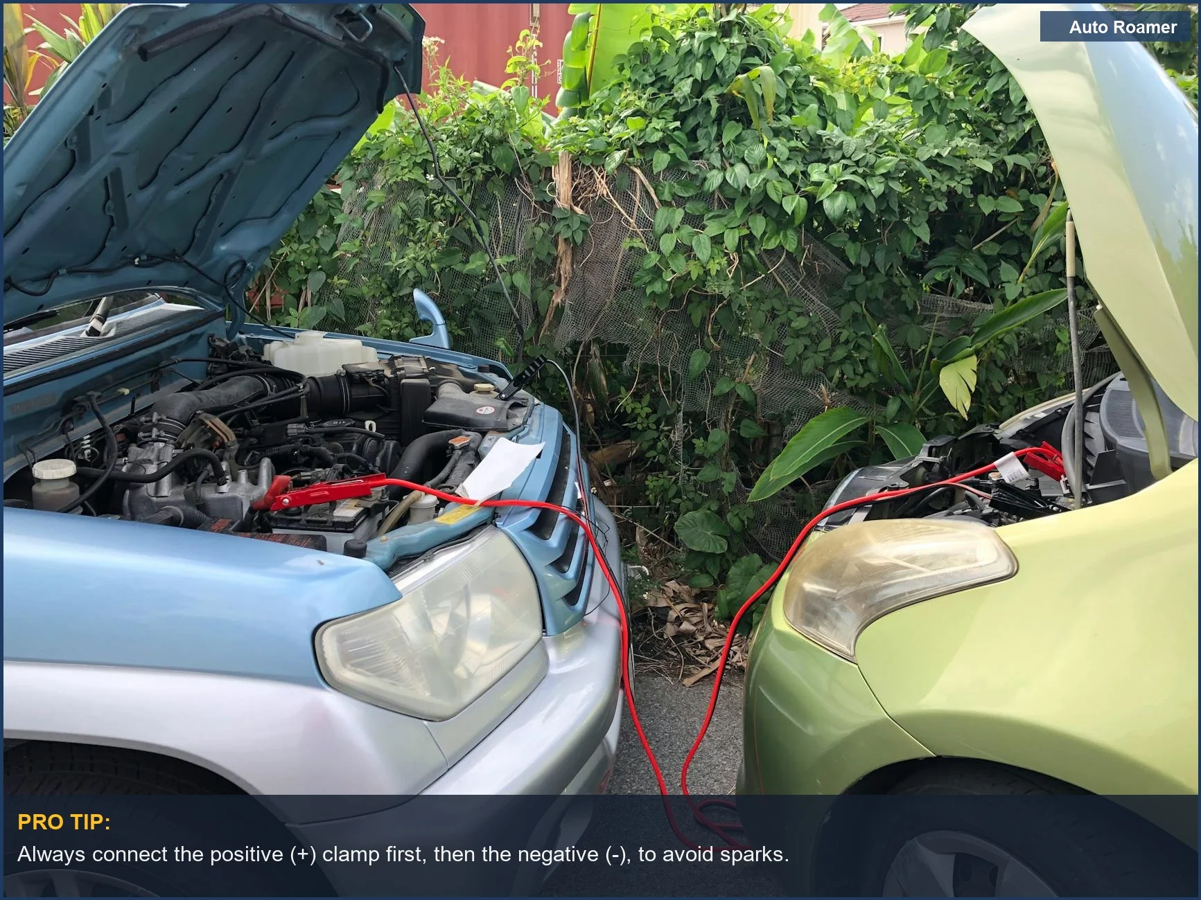 Two cars connected by jumper cables, demonstrating a portable car jump starter's power in 2026.