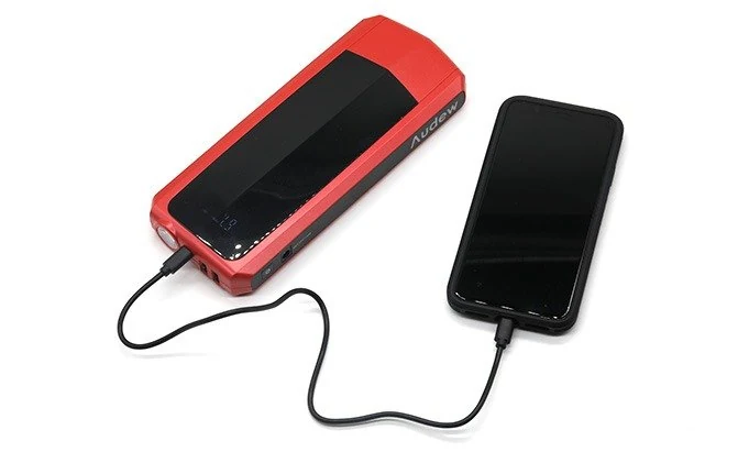 Compact lithium jump starter charging a phone over USB