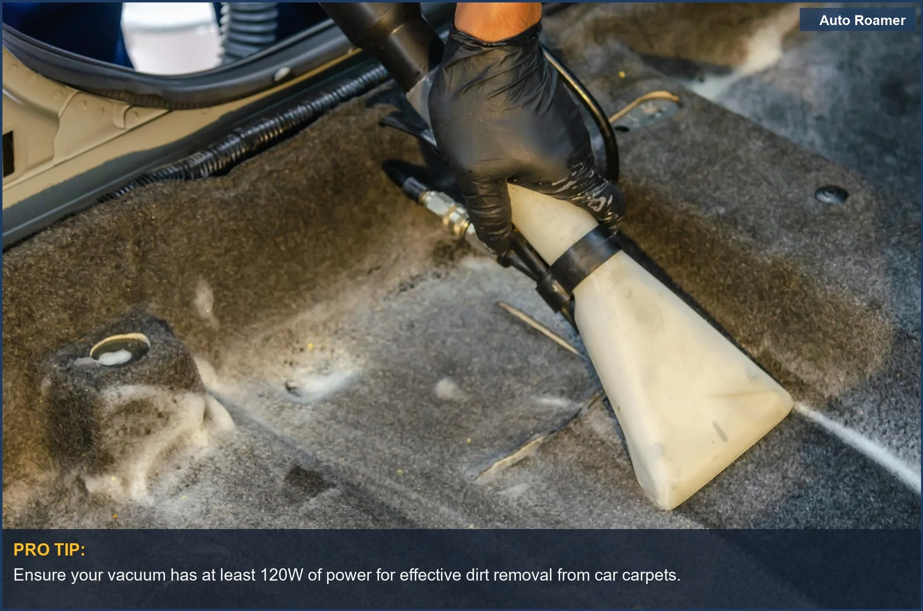 Hands in gloves using a powerful portable car vacuum to extract dirt from upholstery.