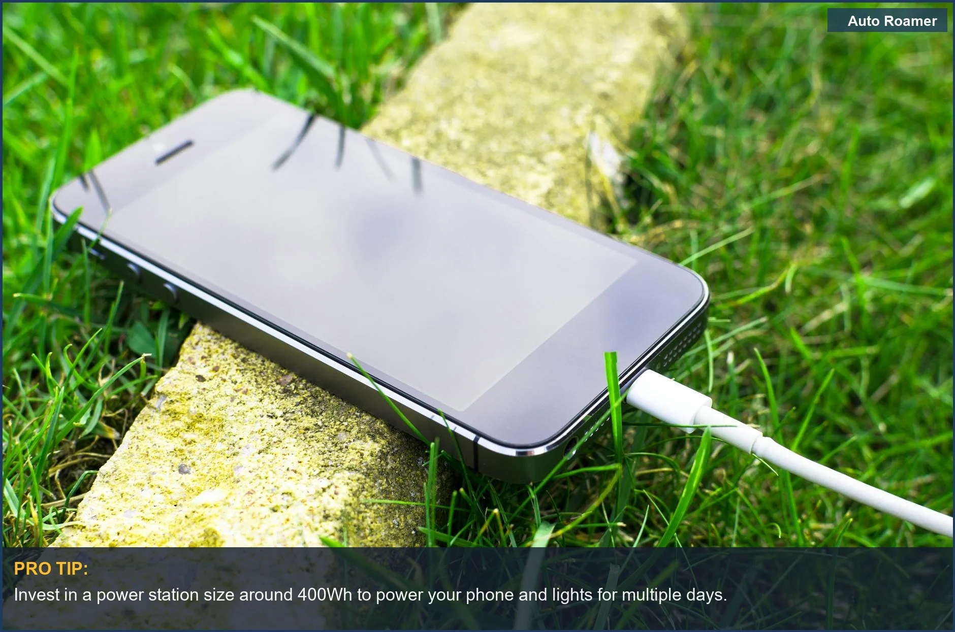 Smartphone connected to a portable power bank outdoors, demonstrating essential car camping power.