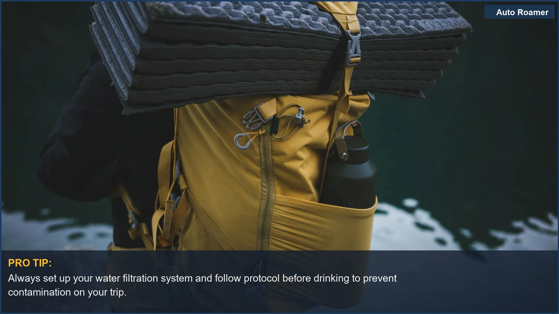 Yellow backpack with camping gear including a water bottle and mat positioned near a water source.