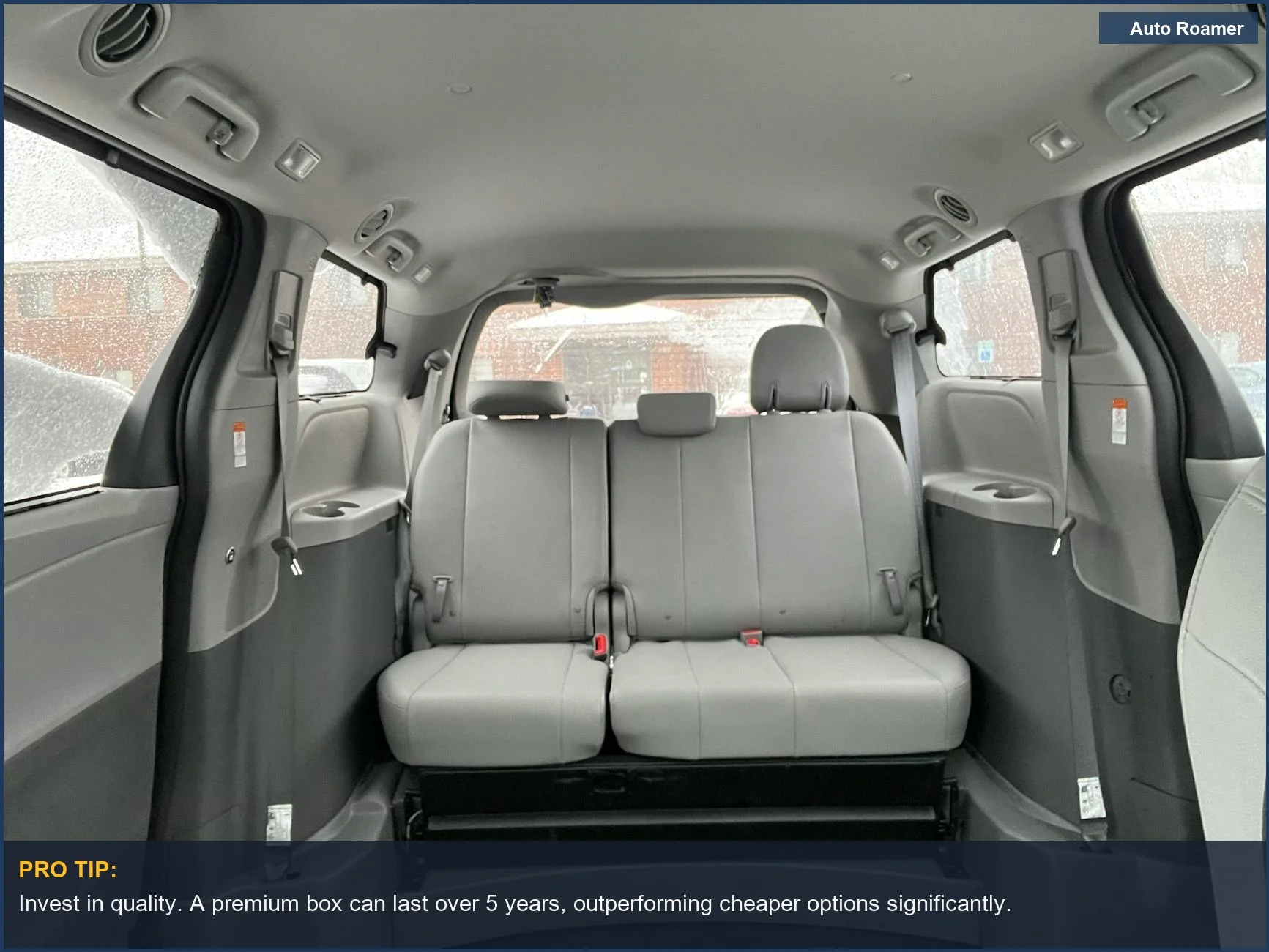 Spacious minivan interior with grey leather seats, ideal for families needing extra storage with a rooftop cargo box.