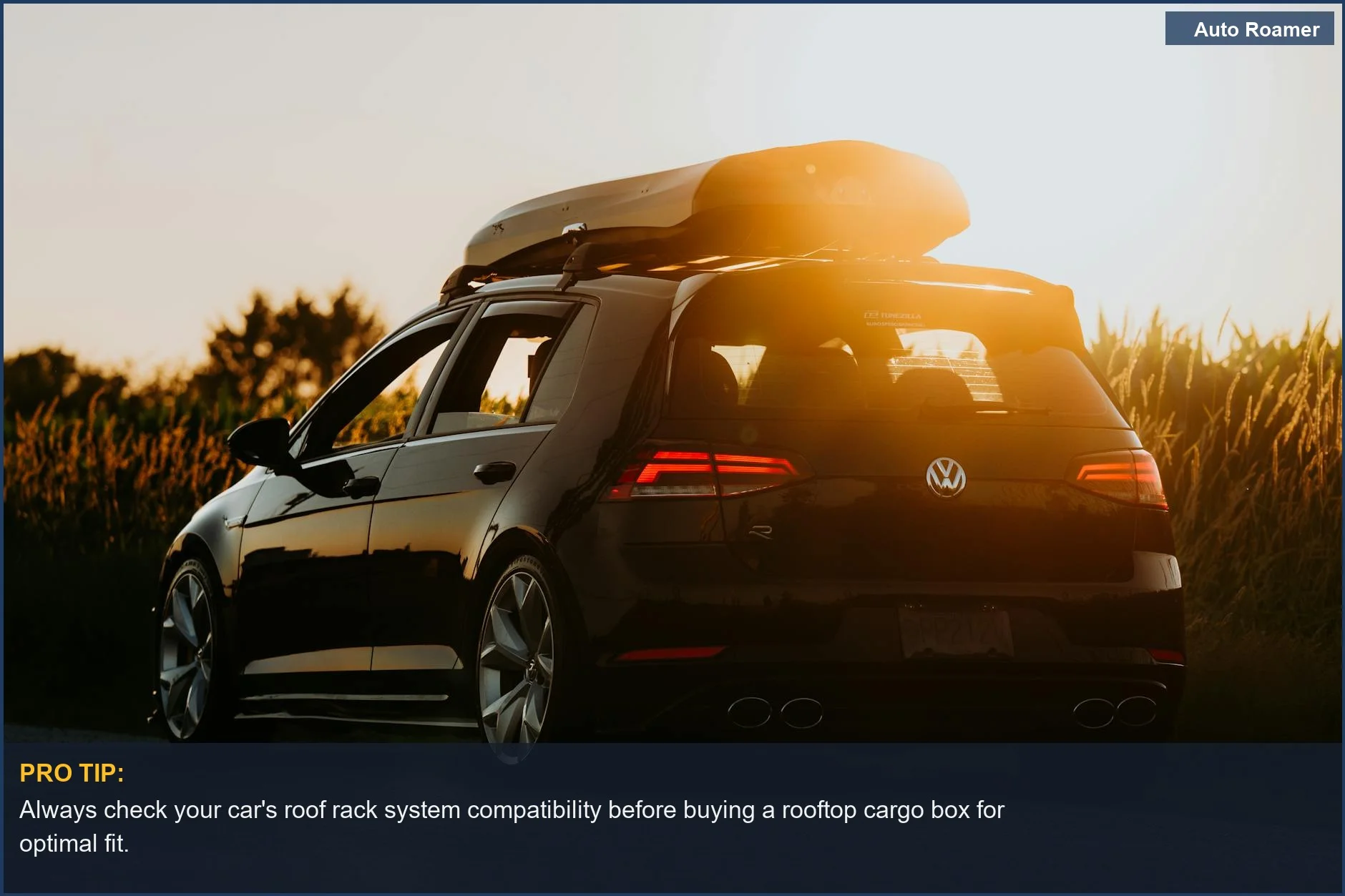 Sleek black car with a roof box parked on a rural road at sunset, symbolizing travel.