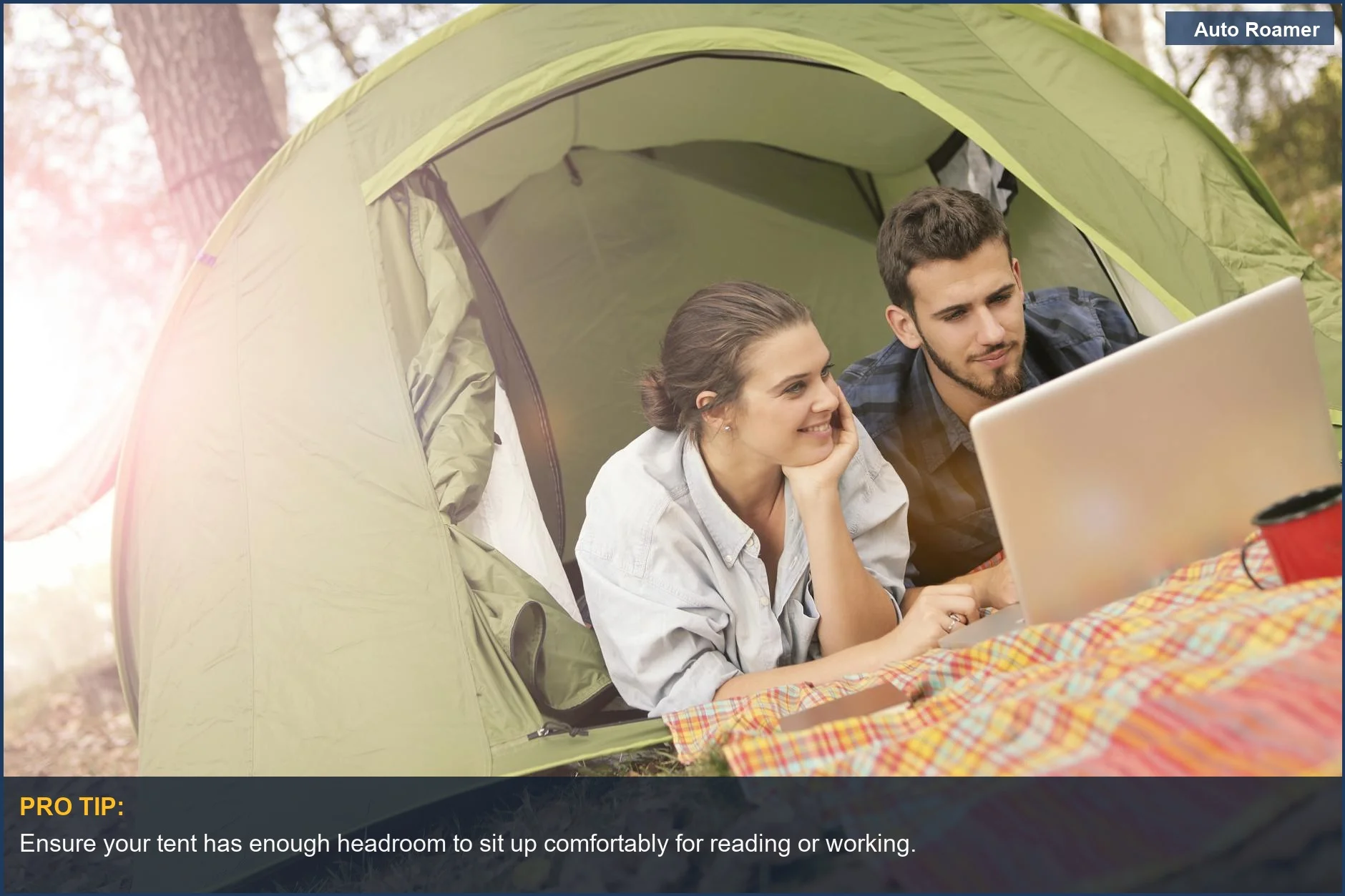 Couple relaxing inside a car camping tent with a laptop, highlighting comfort and convenience.