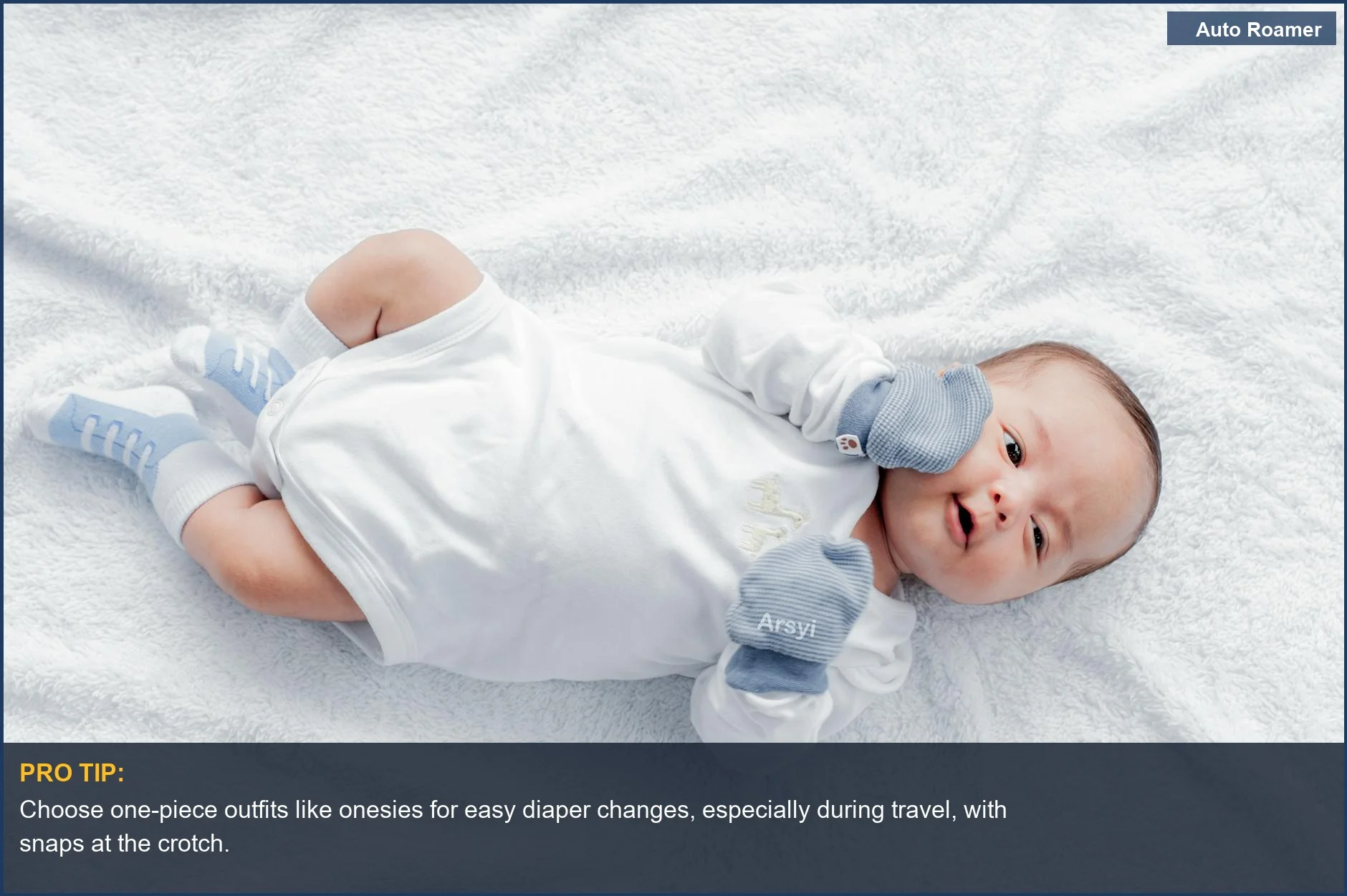 Newborn baby boy in a cozy white onesie with blue mittens, perfect for comfortable baby travel clothes.