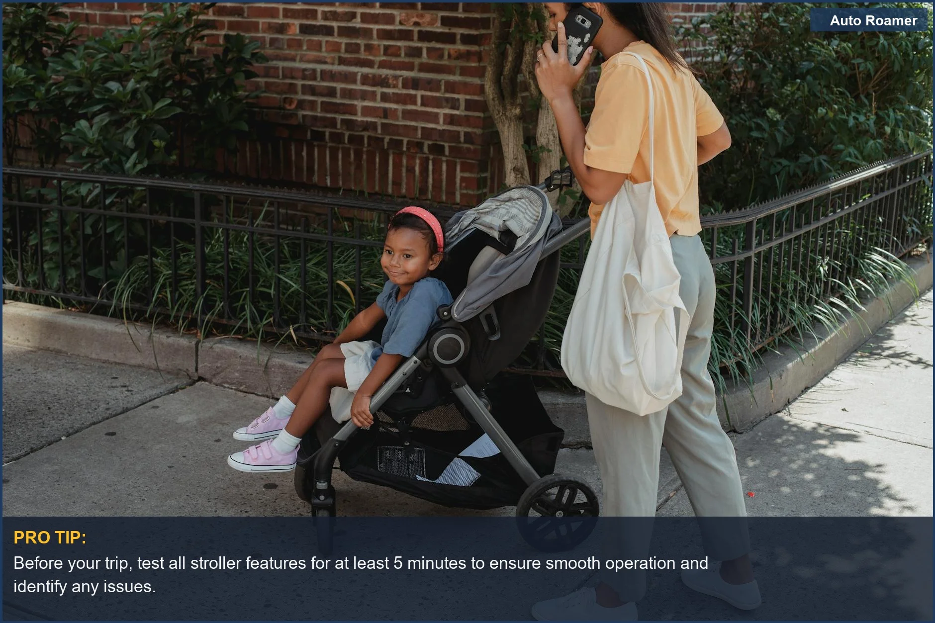 Mother on a phone call while walking her child in a stroller on a sunny sidewalk, demonstrating practical toddler travel solutions.