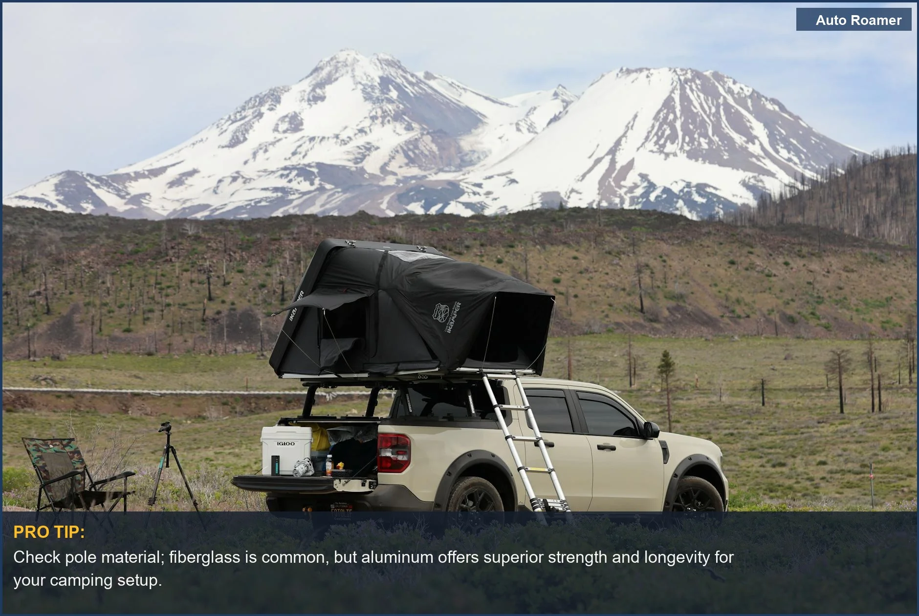 Camioneta robusta con una tienda de techo contra montañas nevadas, perfecta para explorar las mejores tiendas de cama para pick up para acampar.