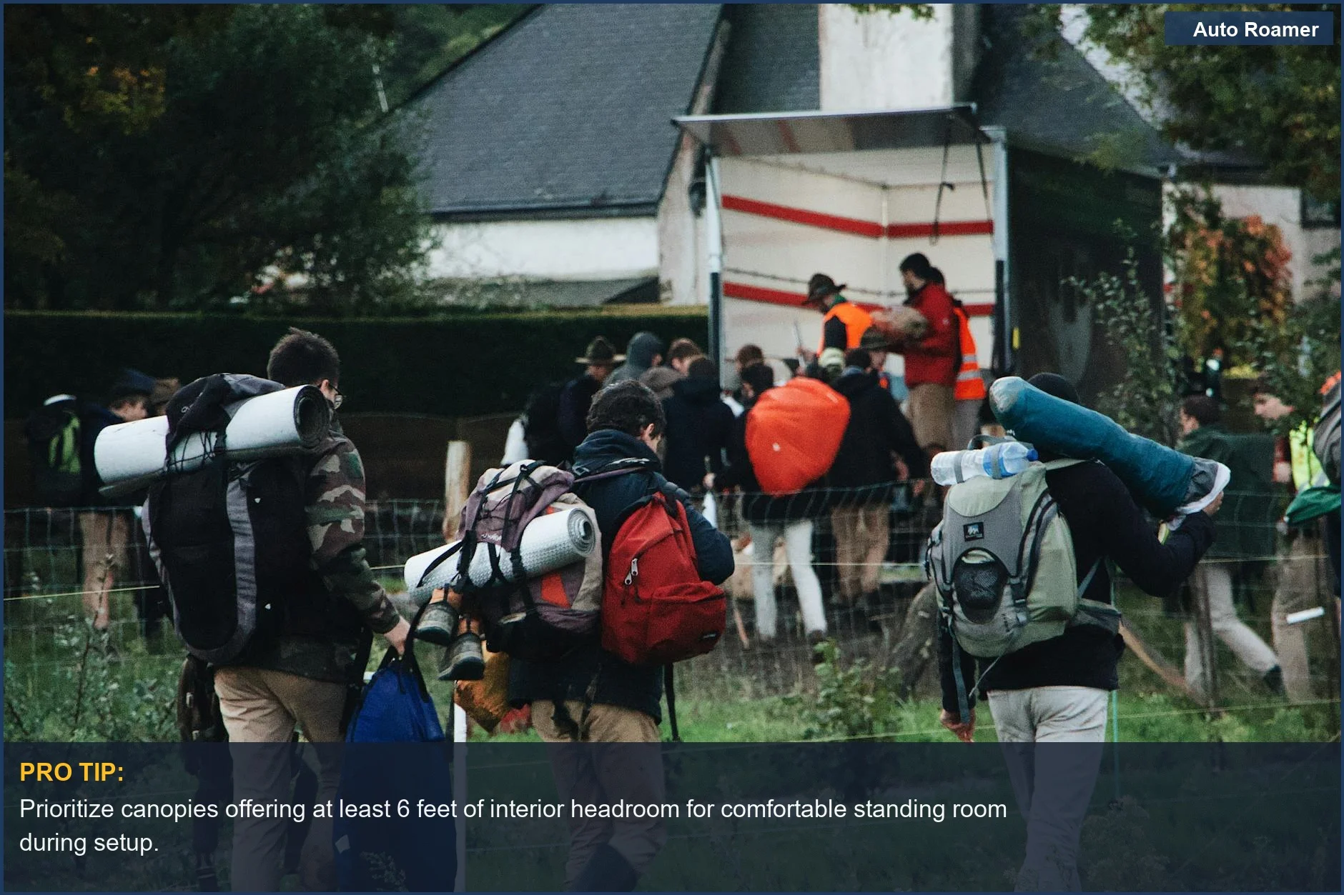 Group of campers with backpacks heading to a truck equipped for an outdoor adventure.