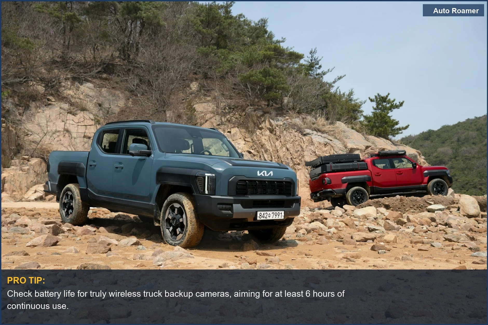 Dos camionetas modernas estacionadas en terreno rocoso, mostrando las mejores opciones de cámaras de reversa inalámbricas para camionetas.