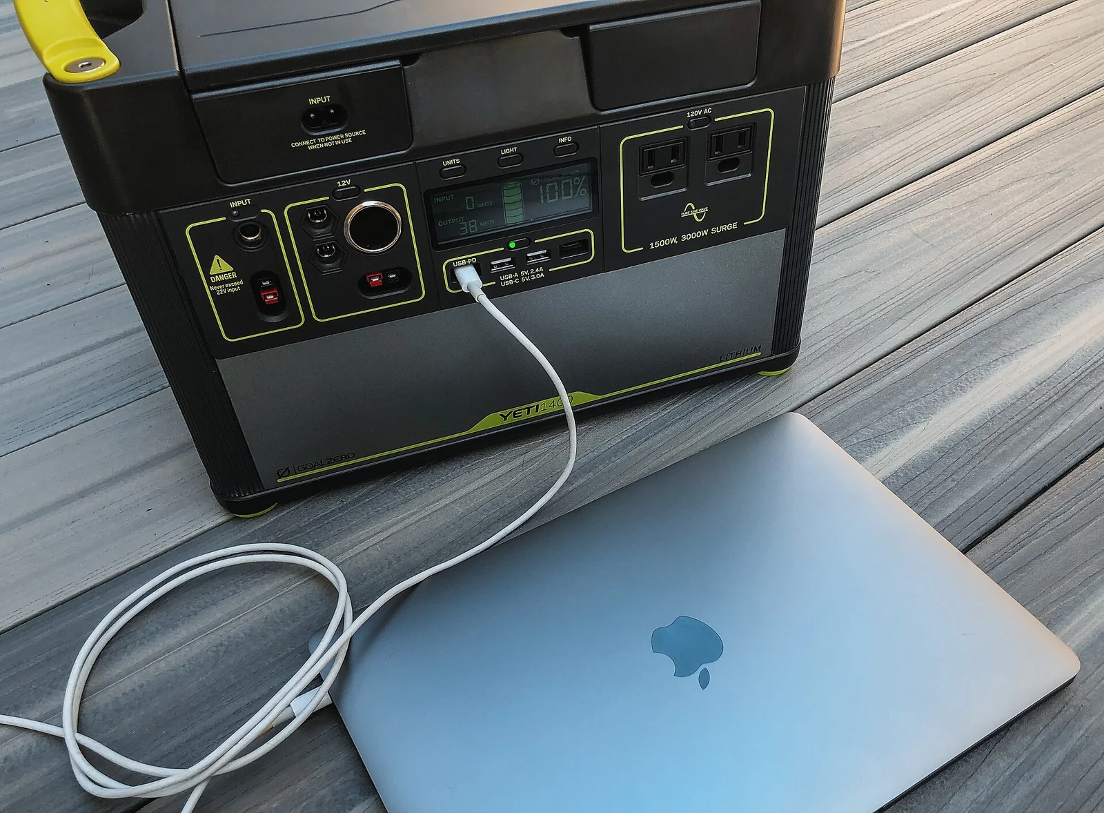 A portable power station running a laptop, the kind of off-grid battery this guide sizes for a weekend of car-camping power.