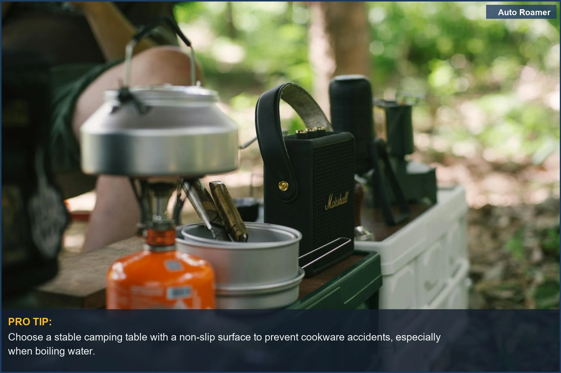 Outdoor forest campsite featuring a stable camping table with a gas stove and kettle, perfect for car camping.