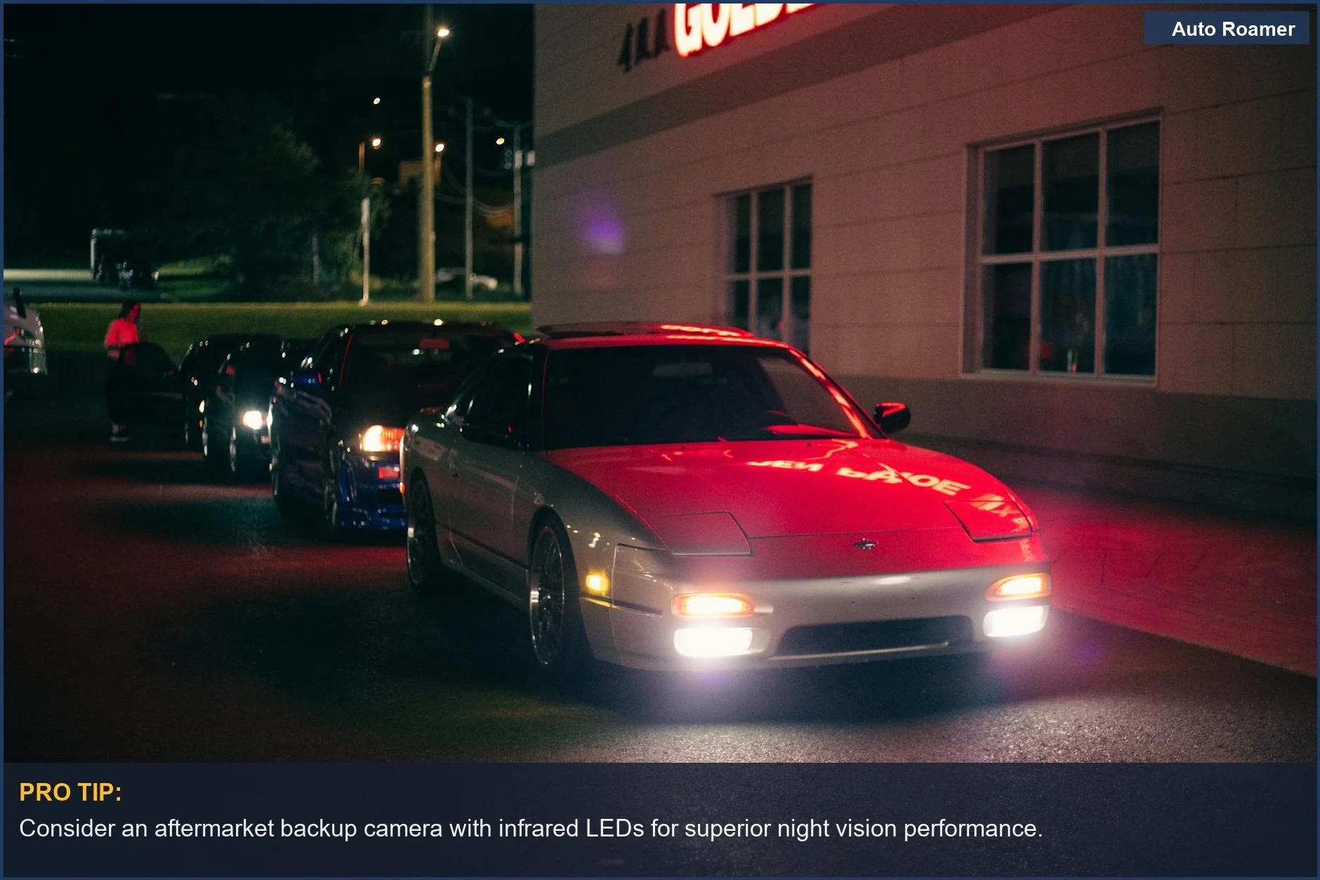 Cars parked at night under neon lights, highlighting the need for good backup camera night vision.