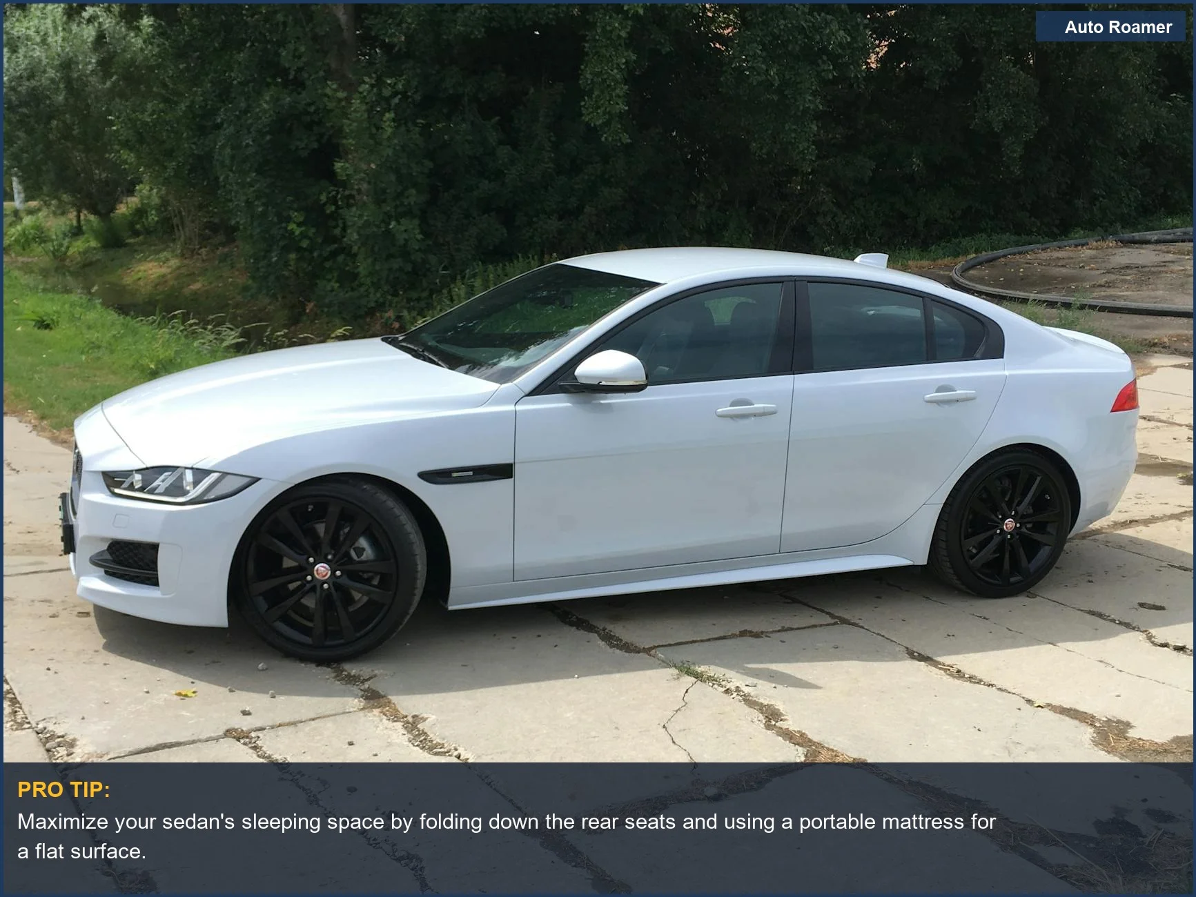 White sedan car camping in the Netherlands, surrounded by lush green scenery for a comfortable overnight stay.