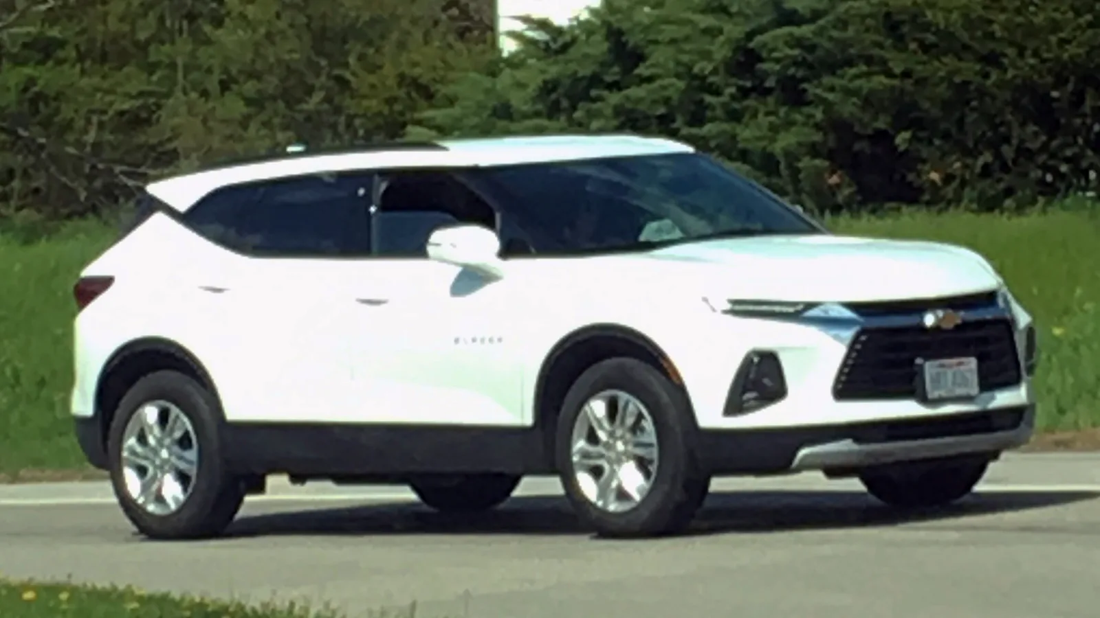 White current-generation Chevrolet Blazer mid-size SUV parked at the roadside in a front three-quarter view, the vehicle a car camper would sleep in