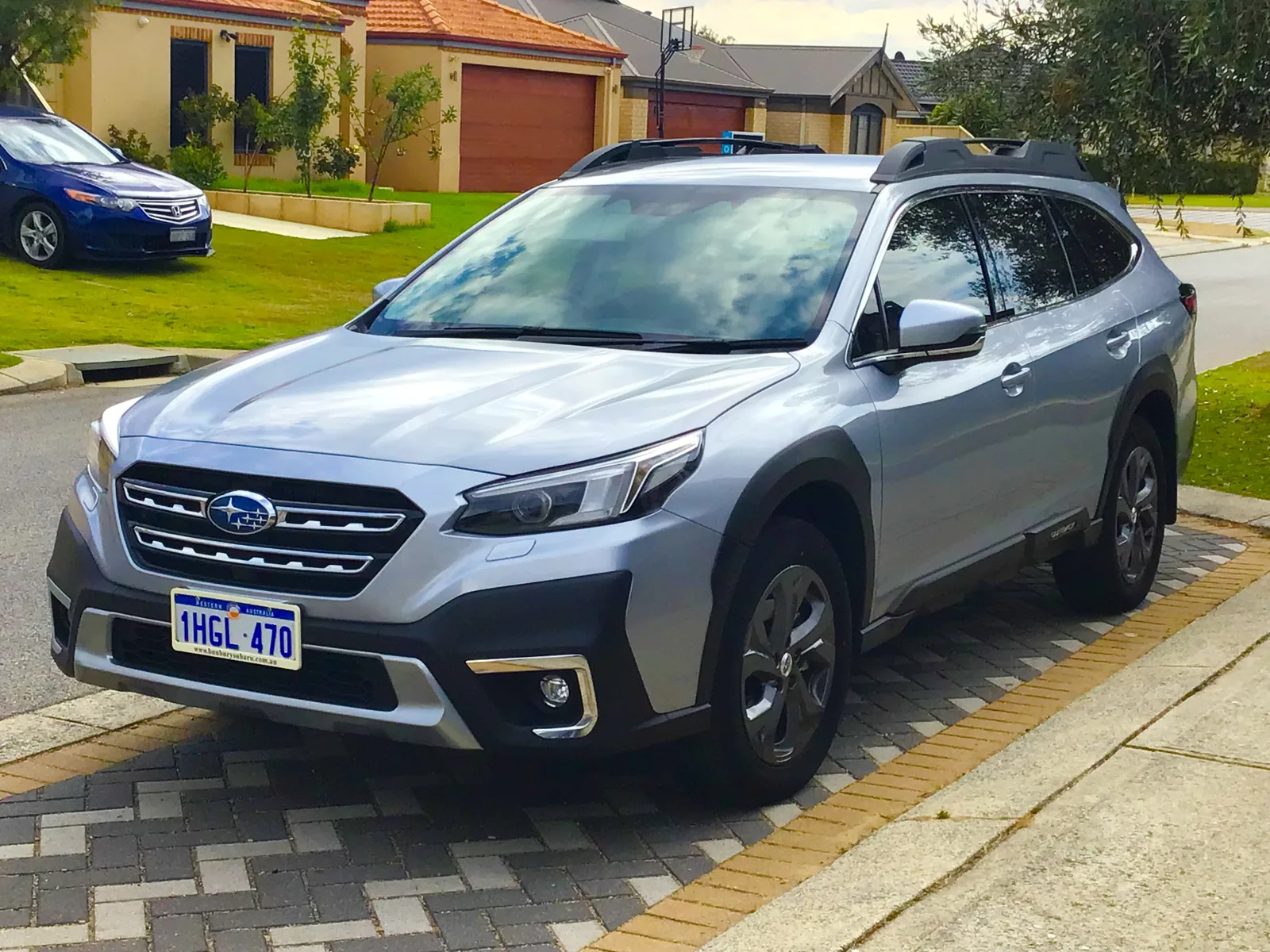 A silver sixth-generation Subaru Outback wagon in a driveway, the model this guide rates for sleeping