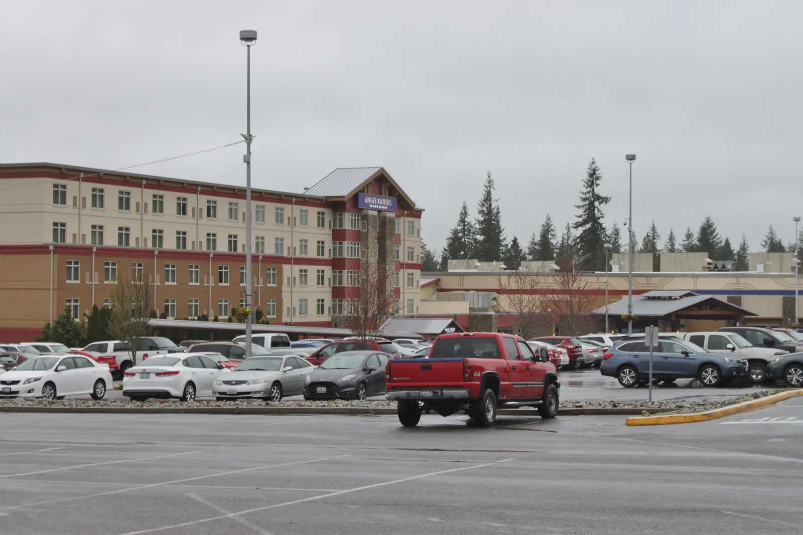 Cars filling a casino resort parking lot with the hotel behind, the kind of lot you sleep in a car at