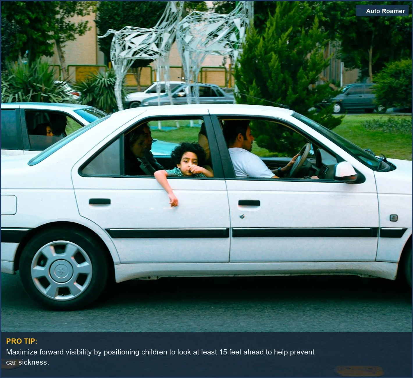 Family enjoying a car ride with a child looking out the window for road trip nausea relief.
