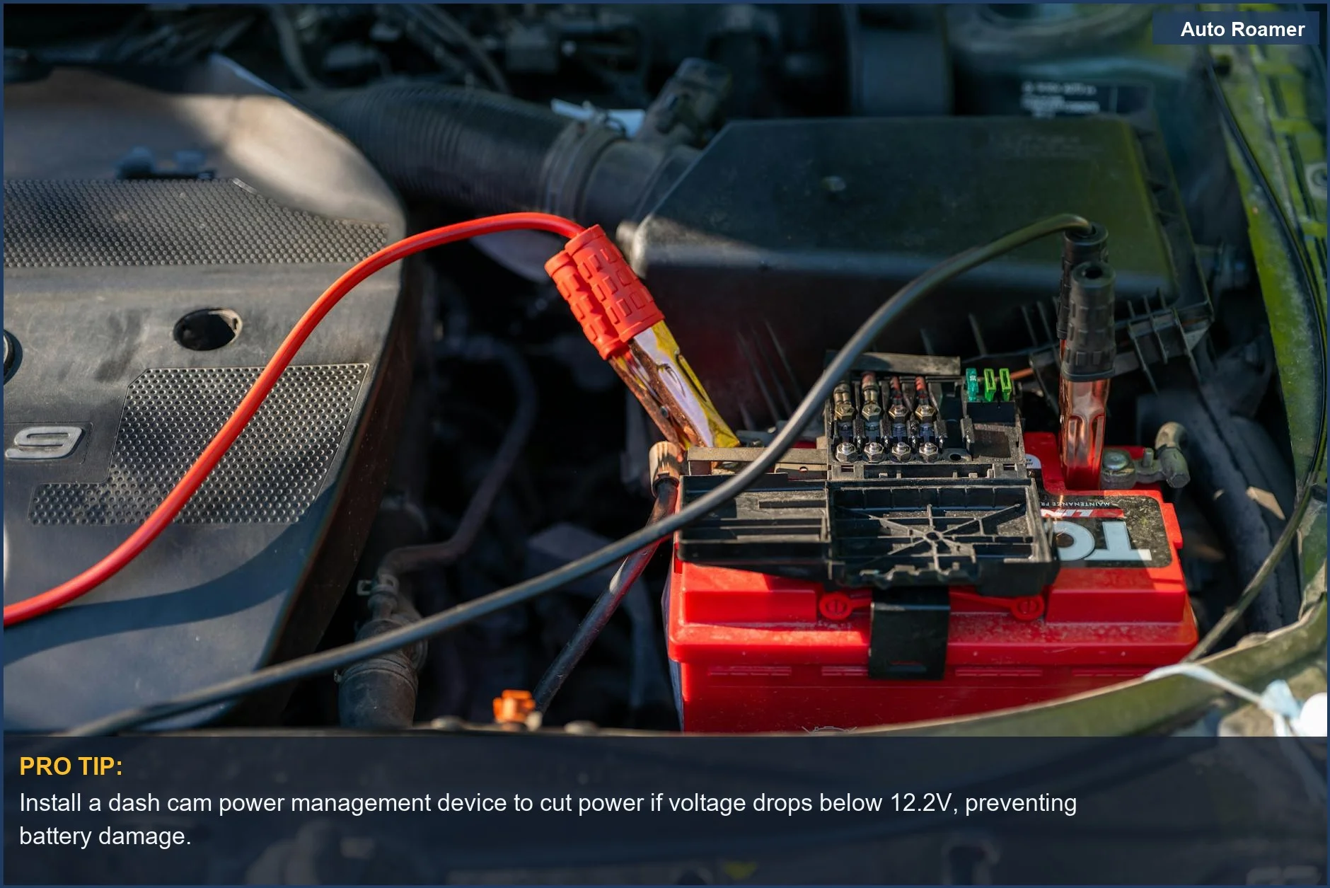Close-up of a car battery with jumper cables attached, highlighting protecting car battery dash cam usage.