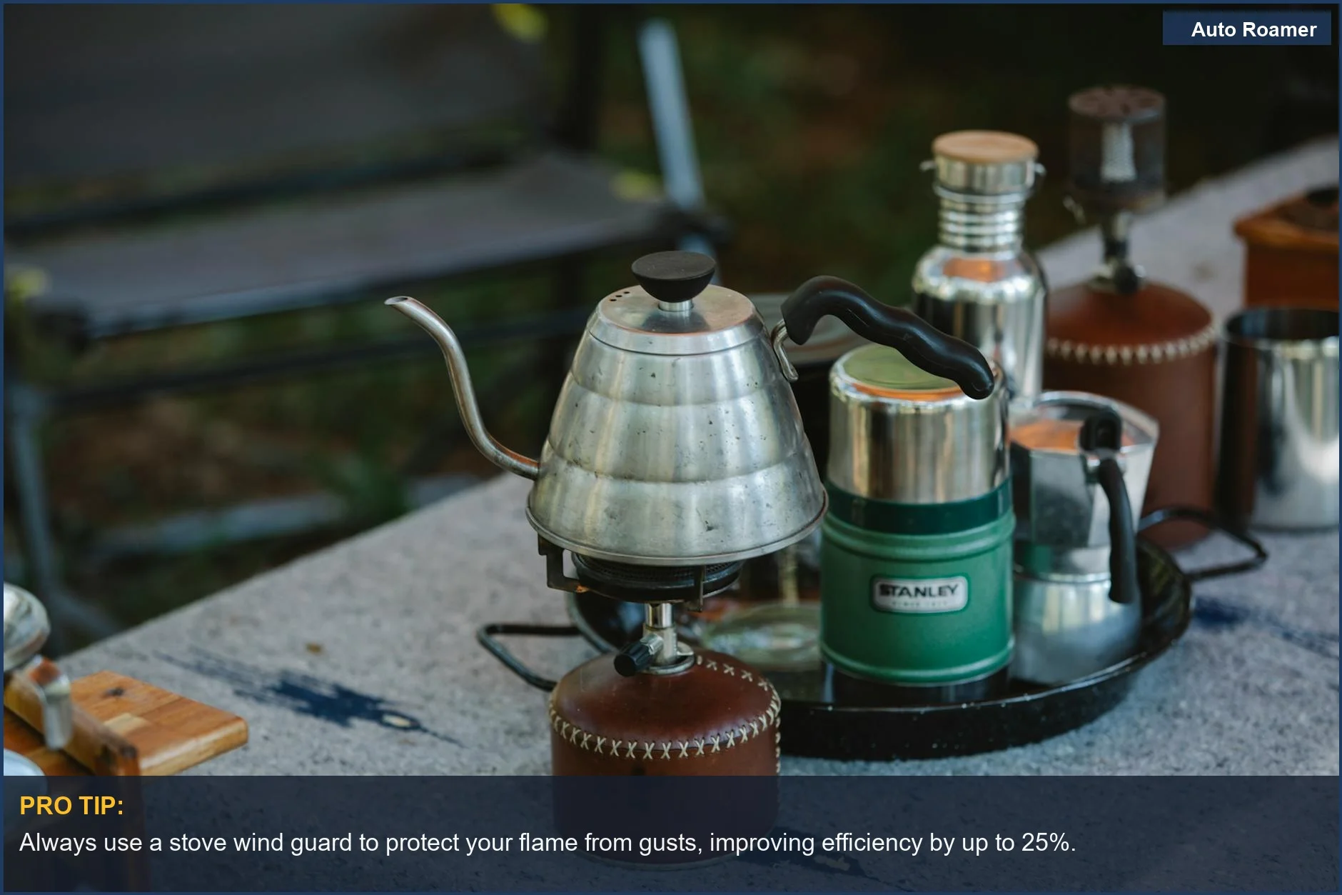 Close-up of a camping stove with a coffee kettle, demonstrating useful stove wind guard and cooking accessories.