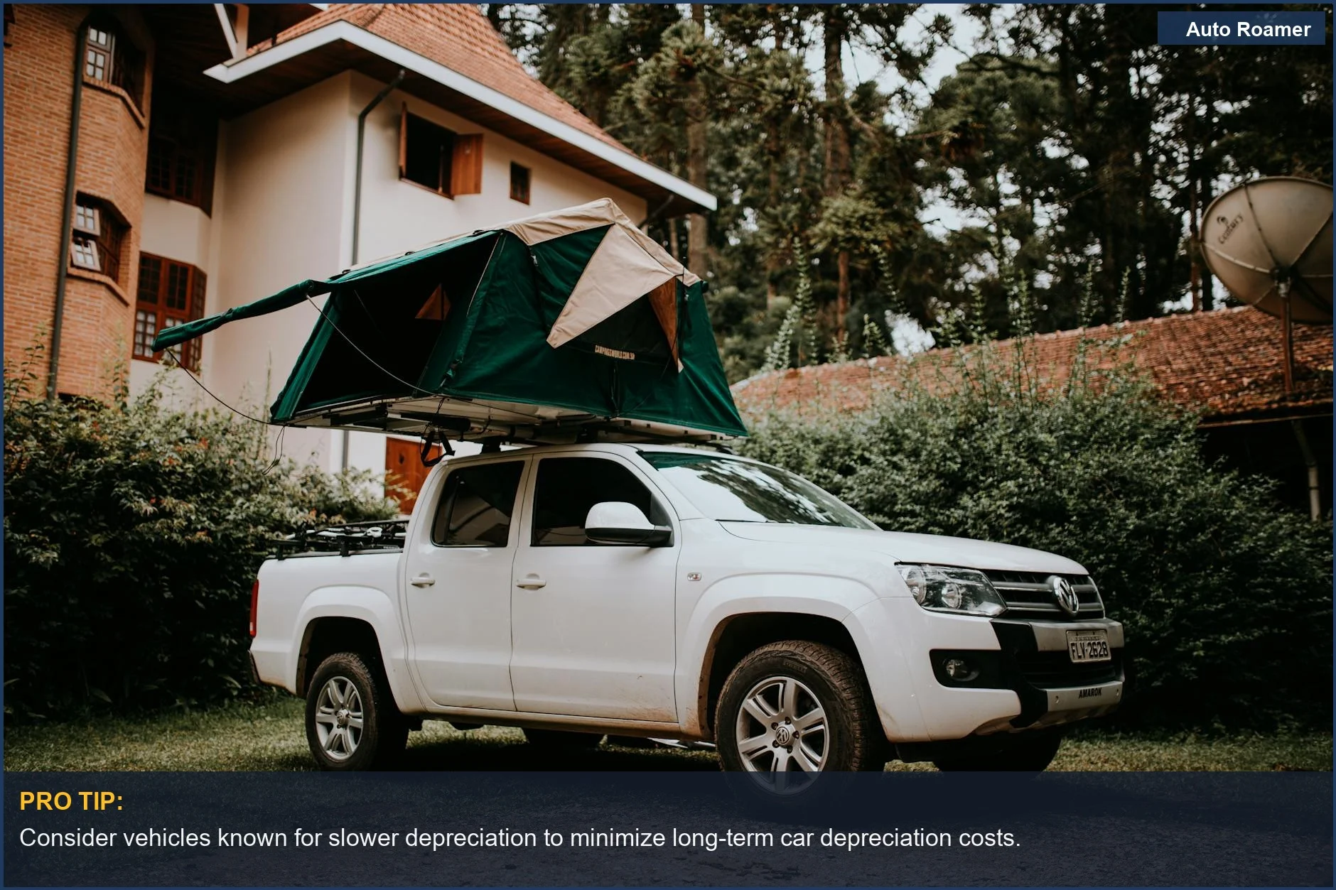 White pickup truck with rooftop tent near a house, symbolizing car depreciation's impact.