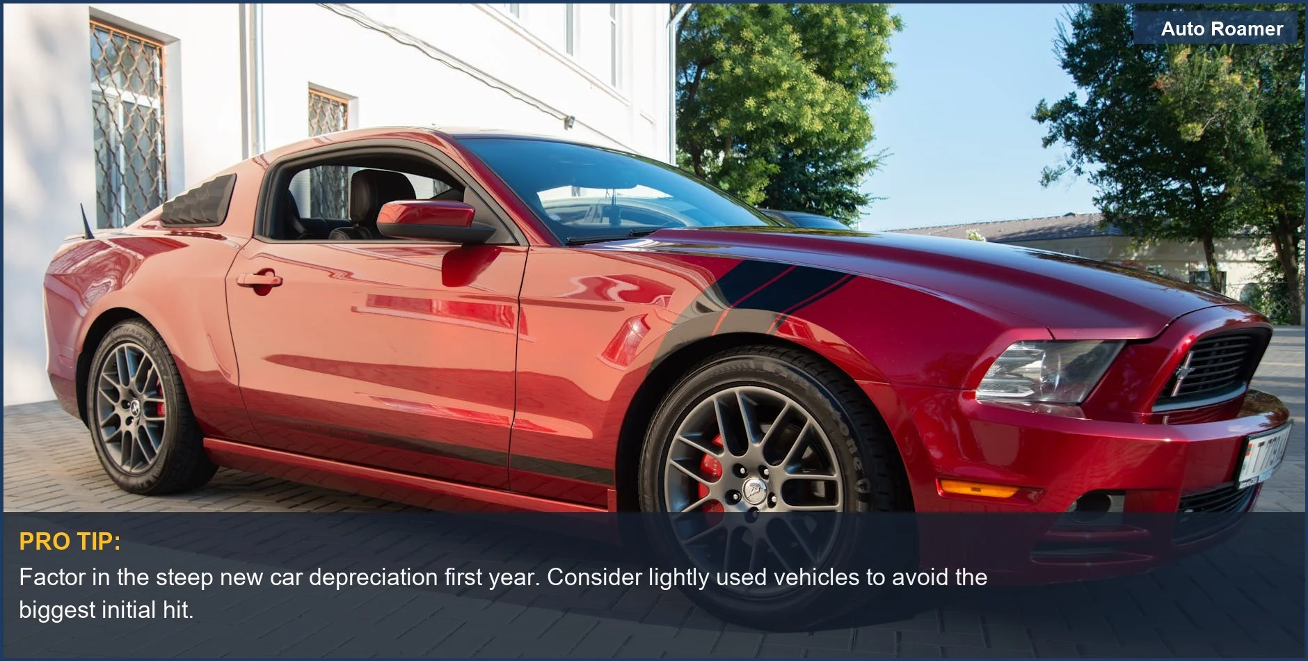 Impresionante Mustang rojo en un camino de entrada iluminado por el sol, destacando las pérdidas de depreciación de un coche nuevo en el primer año.