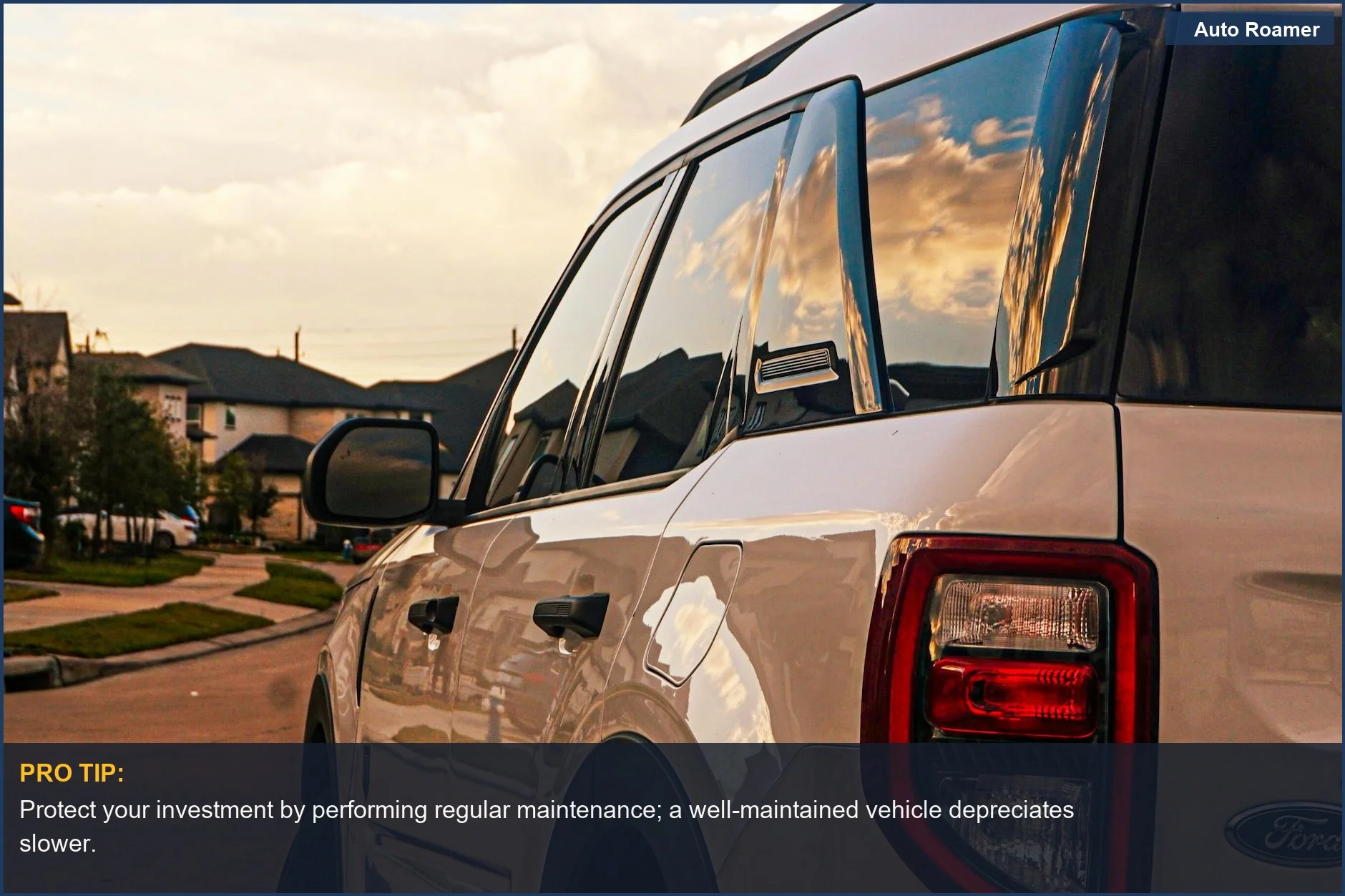 White SUV reflecting sunset on a quiet suburban street, showing new car depreciation first year impact.