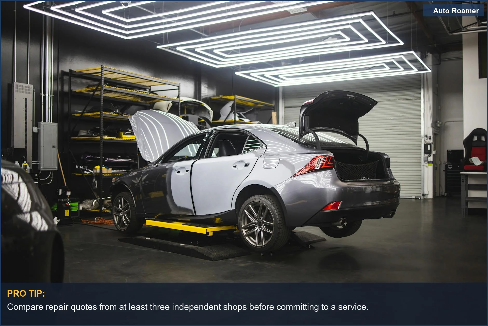 Sleek gray car in a modern repair shop, illustrating the importance of researching car maintenance costs by brand.