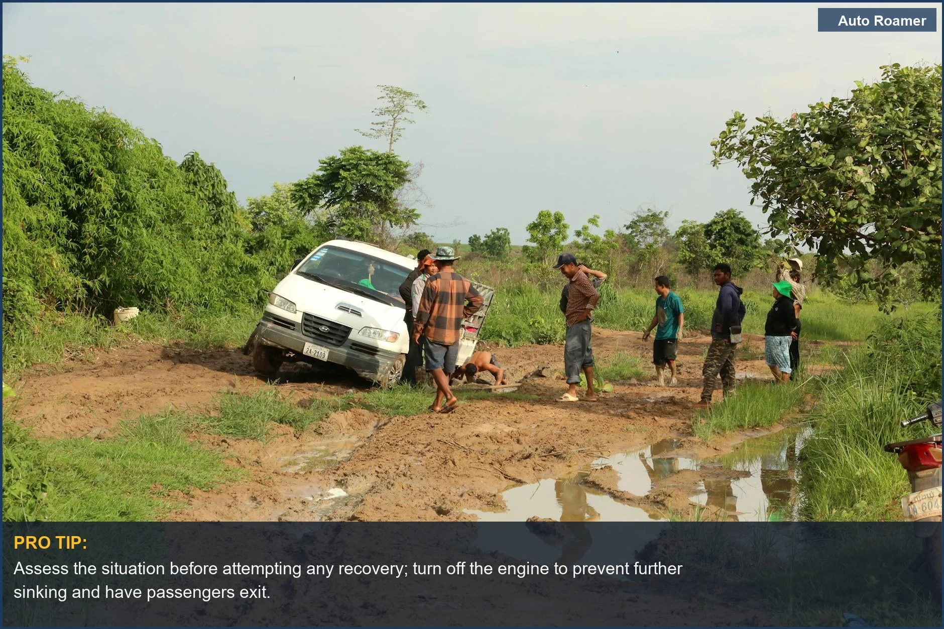 Group of people helping a van stuck on a muddy road, showing how to get a car unstuck from mud.