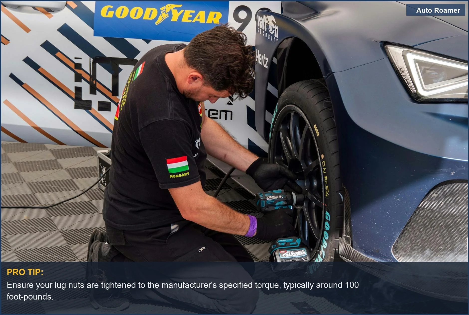 Professional car maintenance: mechanic uses power tools to fix a tire at a service station.