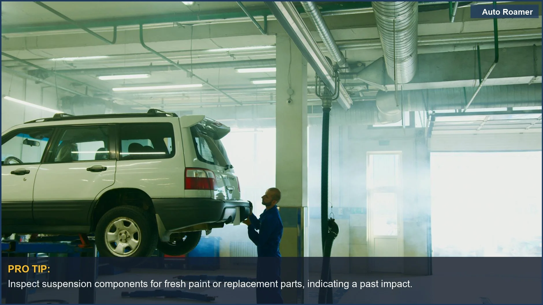 Mechanic carefully inspecting a used family car's engine bay for signs of accident repair.