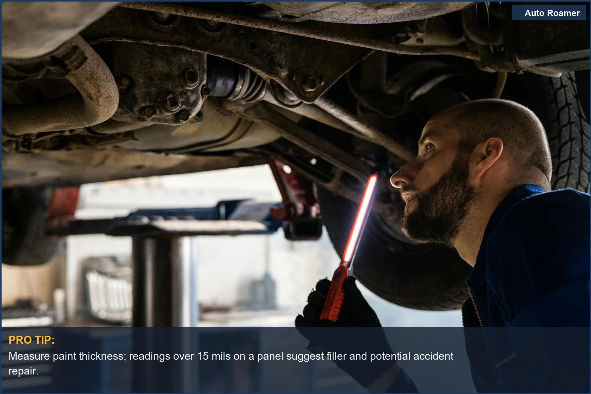 Close-up of a mechanic using a paint thickness gauge to detect accident repair on a car door.