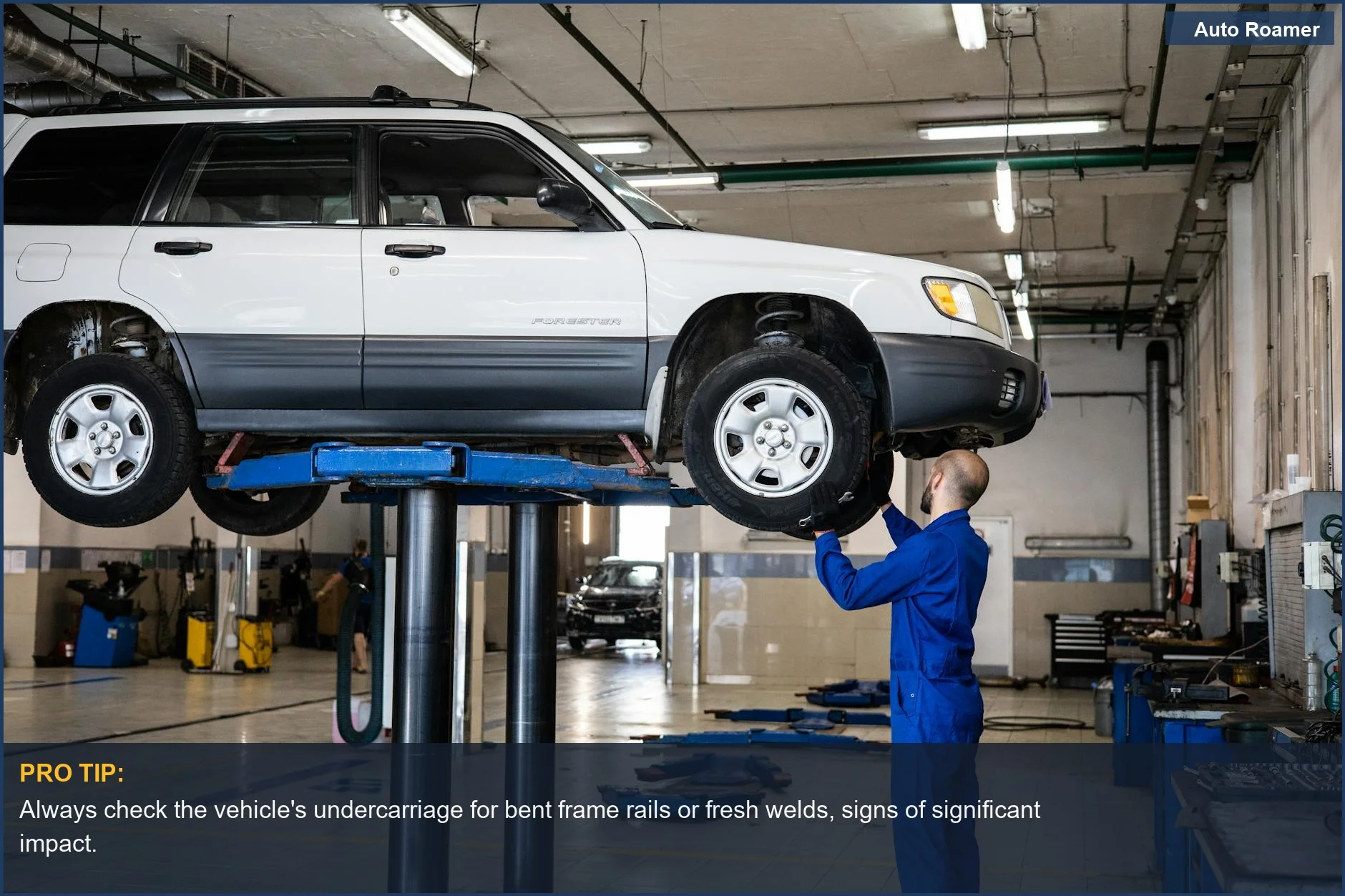 Mechanic inspects a white SUV's undercarriage on a lift for potential accident damage.