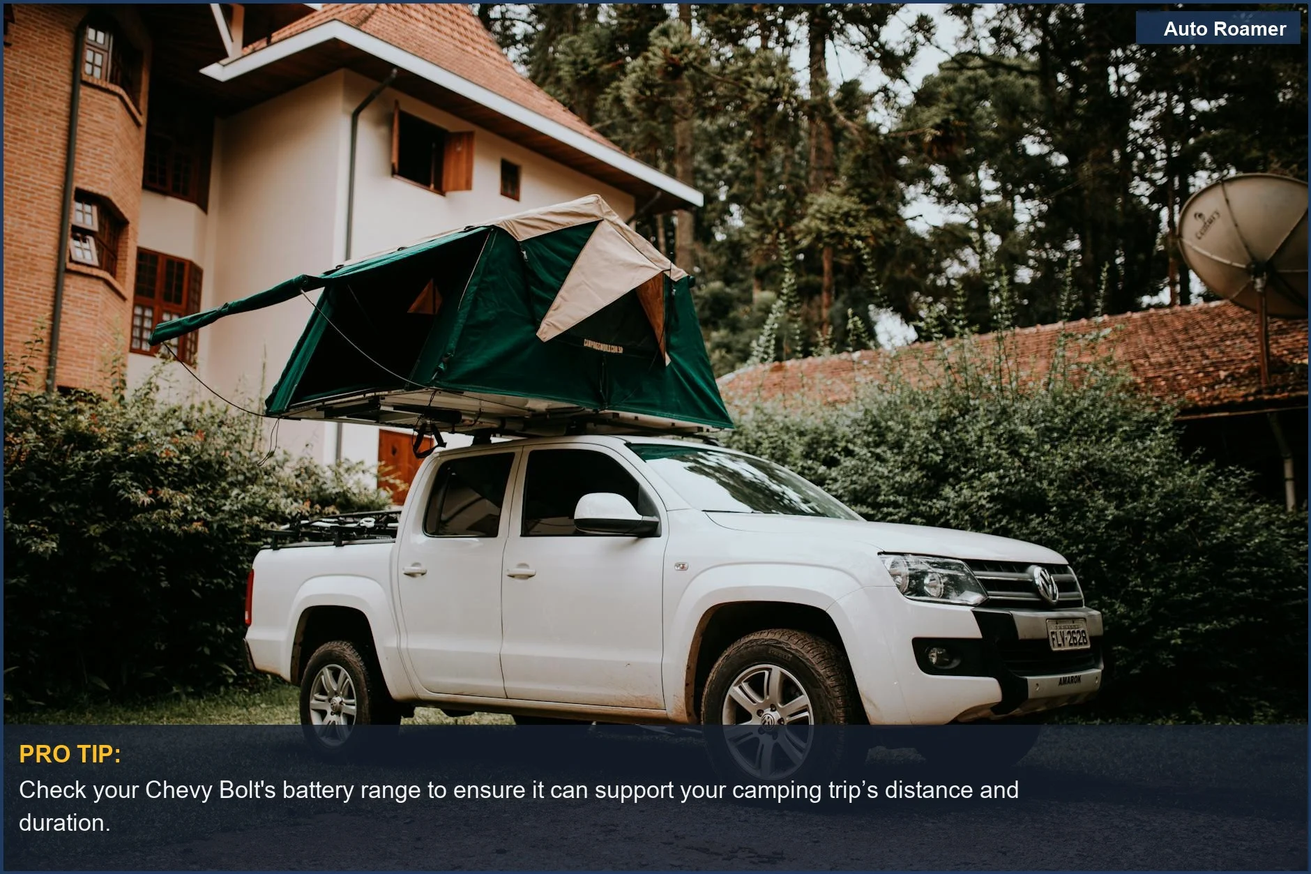 White pickup truck with rooftop tent parked near a house, symbolizing camping and travel themes.