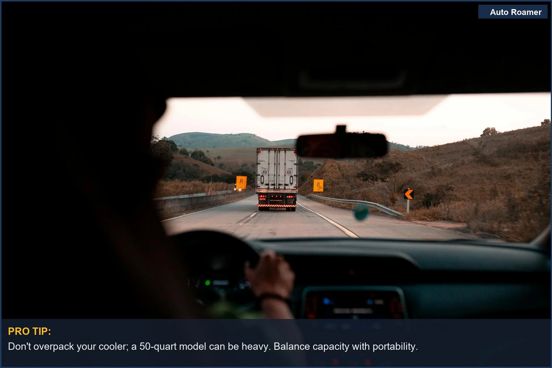Camión en una autopista rodeado de colinas, ilustrando el impacto de las dimensiones de la nevera en los viajes.