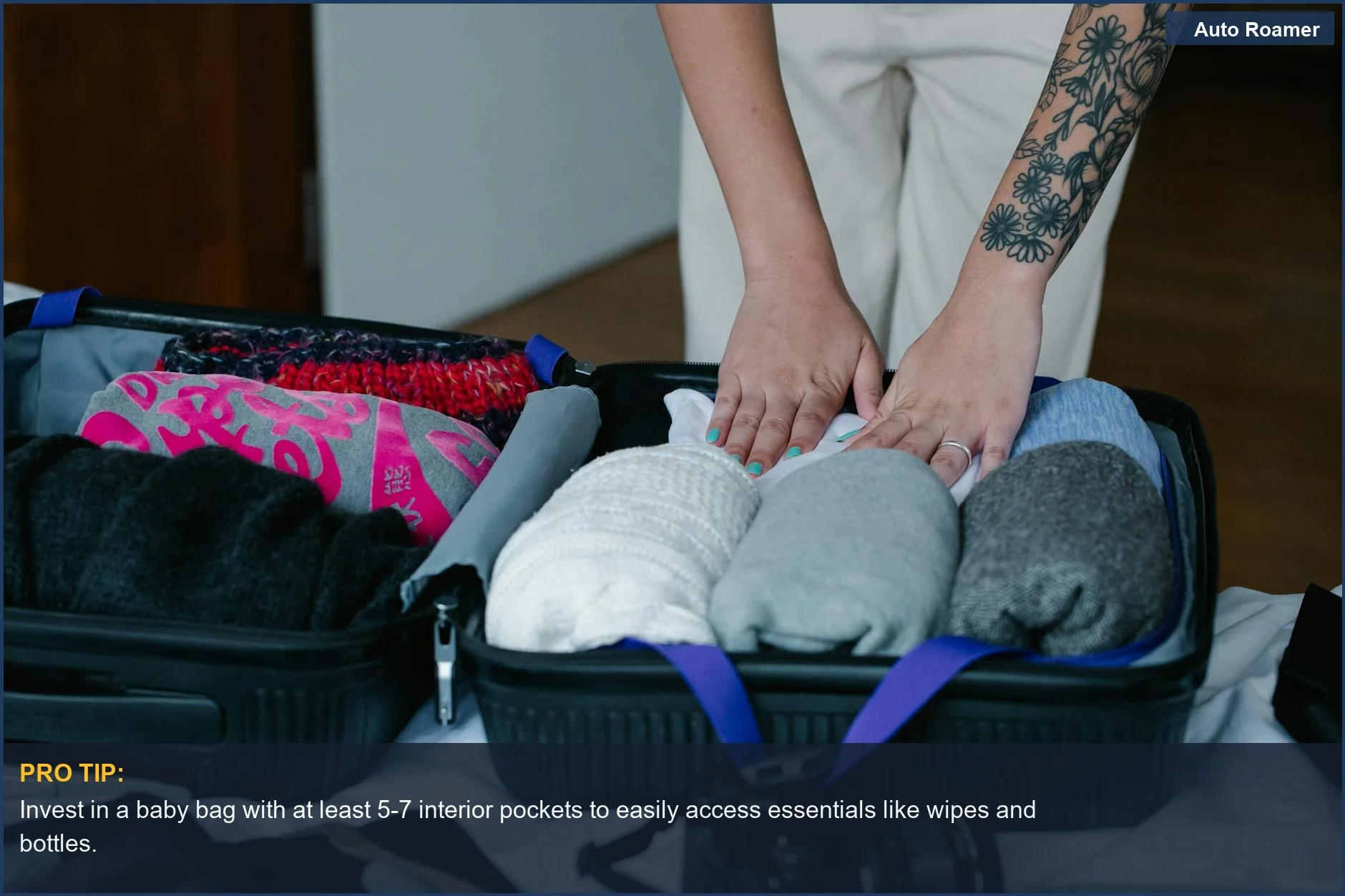 Persona empaca cuidadosamente ropa en equipaje en interiores, demostrando un embalaje eficiente para una guía de tamaño de bolso de bebé.