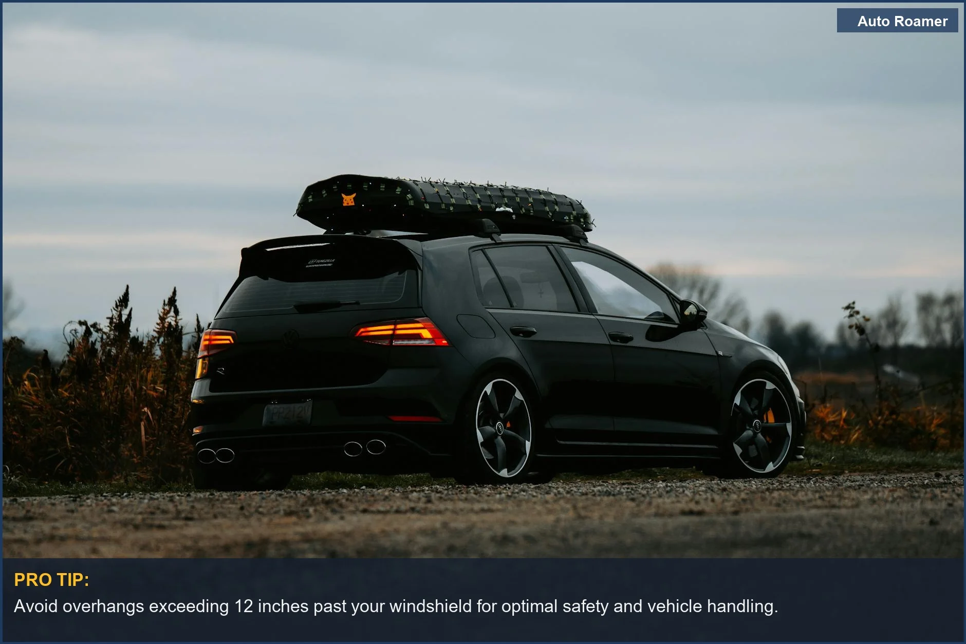 Dark hatchback with a large roof storage box, demonstrating the importance of roof box size for vehicle balance.