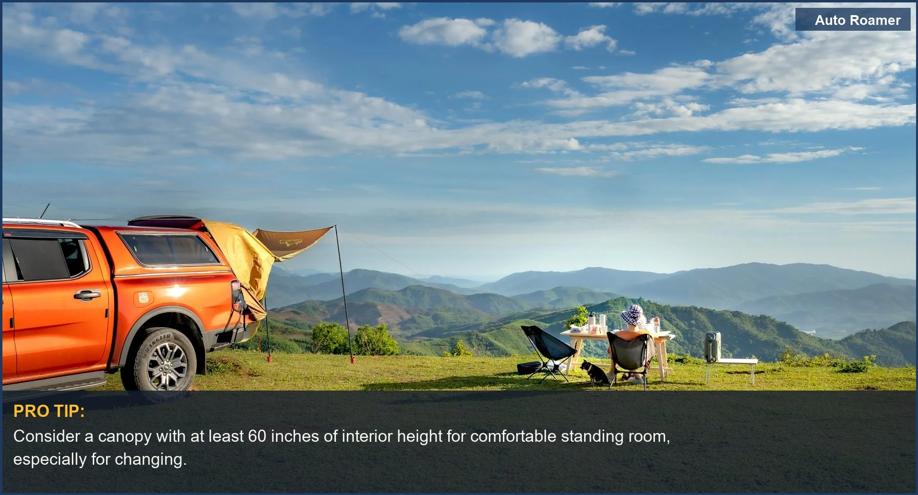 Camping setup with chairs and table beside orange pickup truck overlooking mountains, ideal camper shell dimensions for comfort.