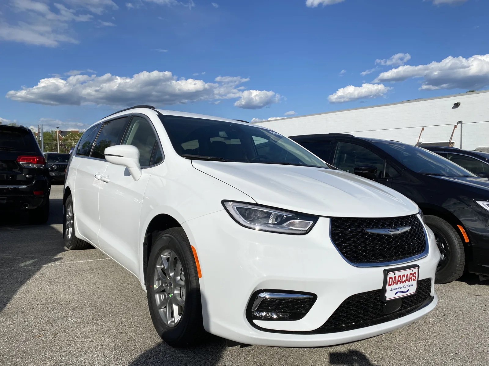 A white Chrysler Pacifica minivan, the vehicle whose cargo dimensions for sleeping this guide measures