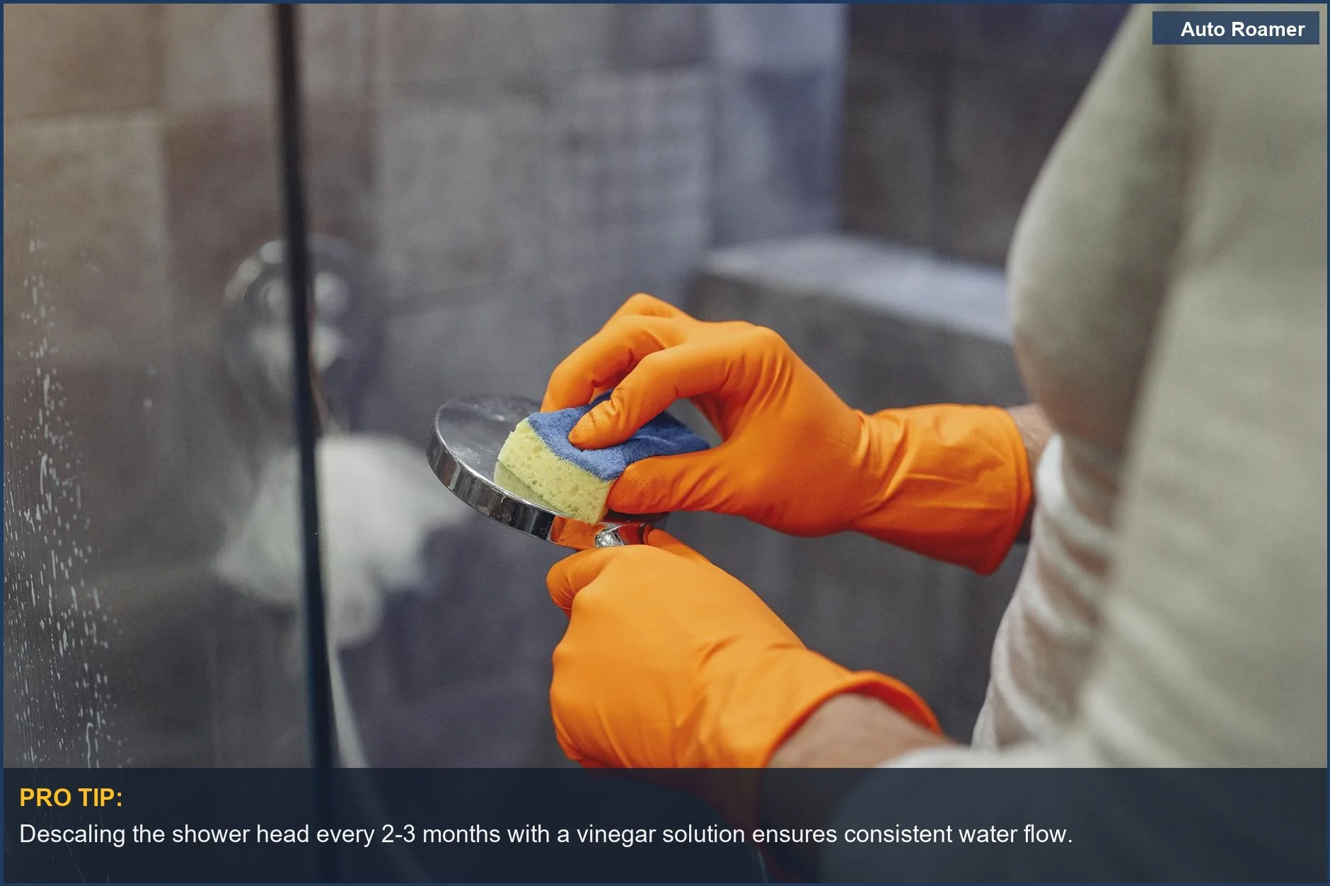 Primer plano de las manos de un hombre con guantes naranjas limpiando un cabezal de ducha con una esponja, esencial para el cuidado de la ducha portátil.