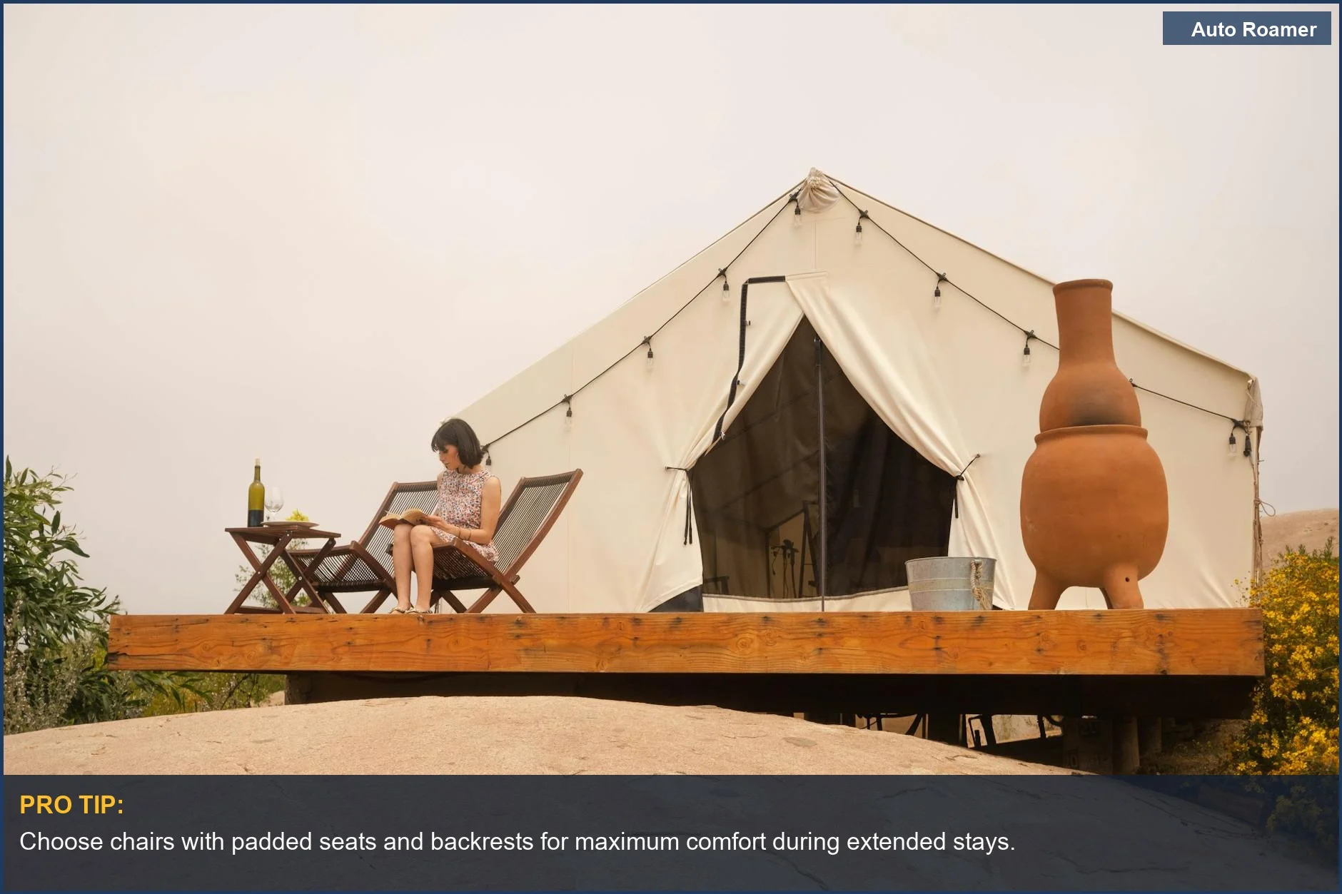 Woman relaxing in a comfortable camping chair, enjoying wine and nature near a glamping tent.
