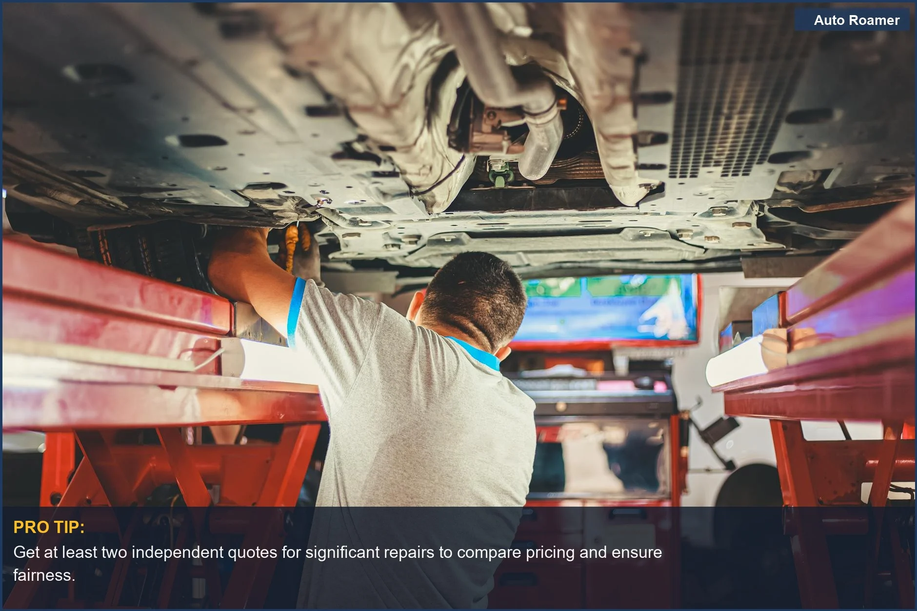 Close-up of a mechanic's hands working on car parts under a lifted vehicle, preventing car repair fraud.