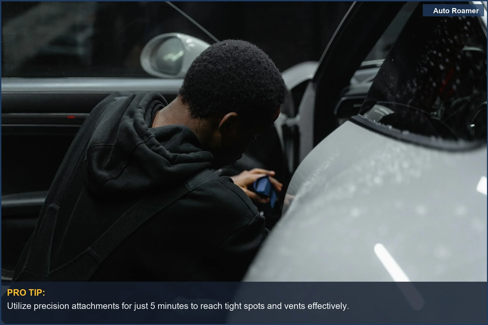 Precision detailing of luxury car interior with a portable vacuum, highlighting meticulous care.